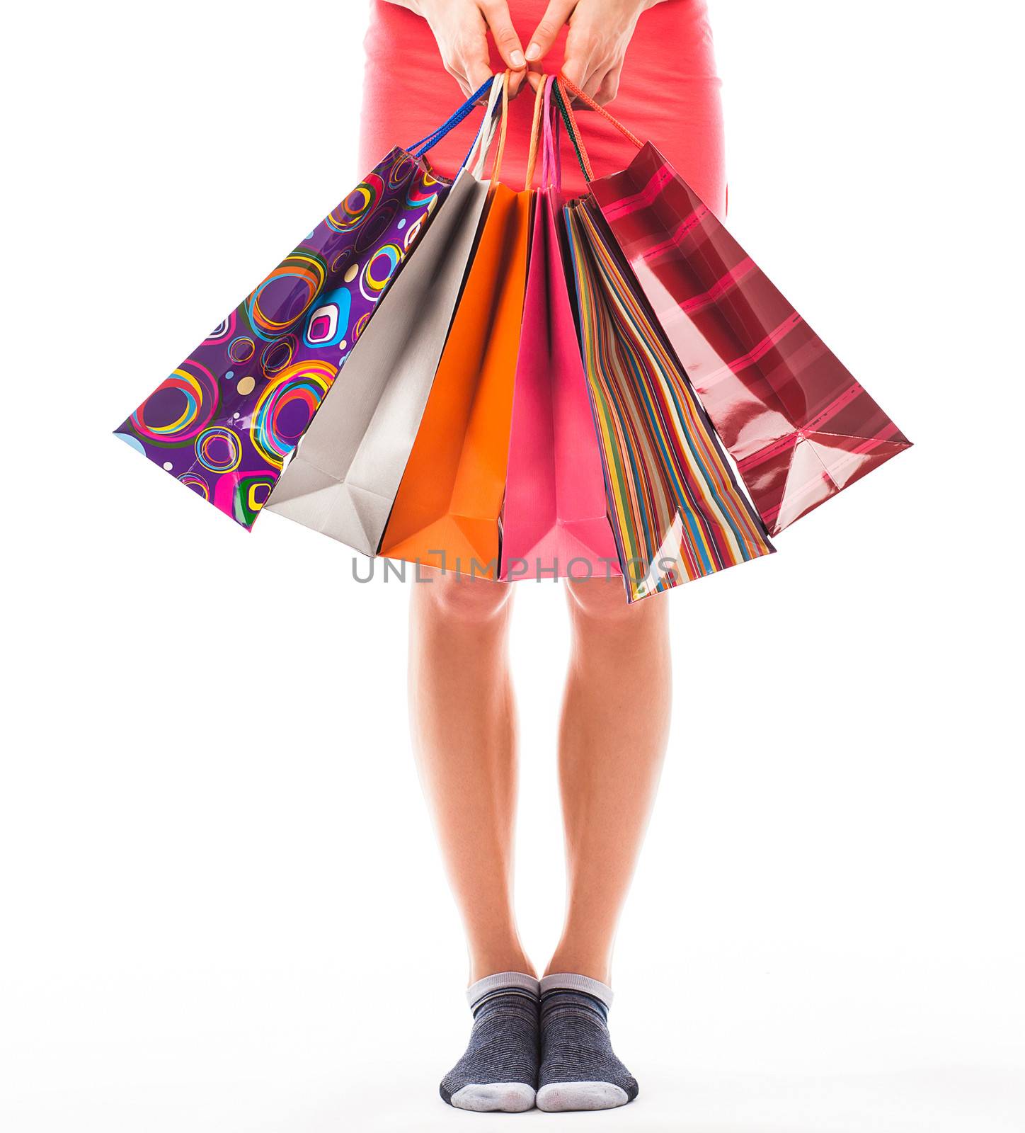 Young woman holding shopping bags, view of her lower body 