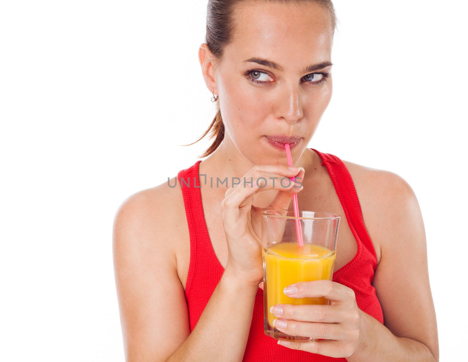 Portrait of a woman drinking an orange juice with a straw and looking something, isolated on white