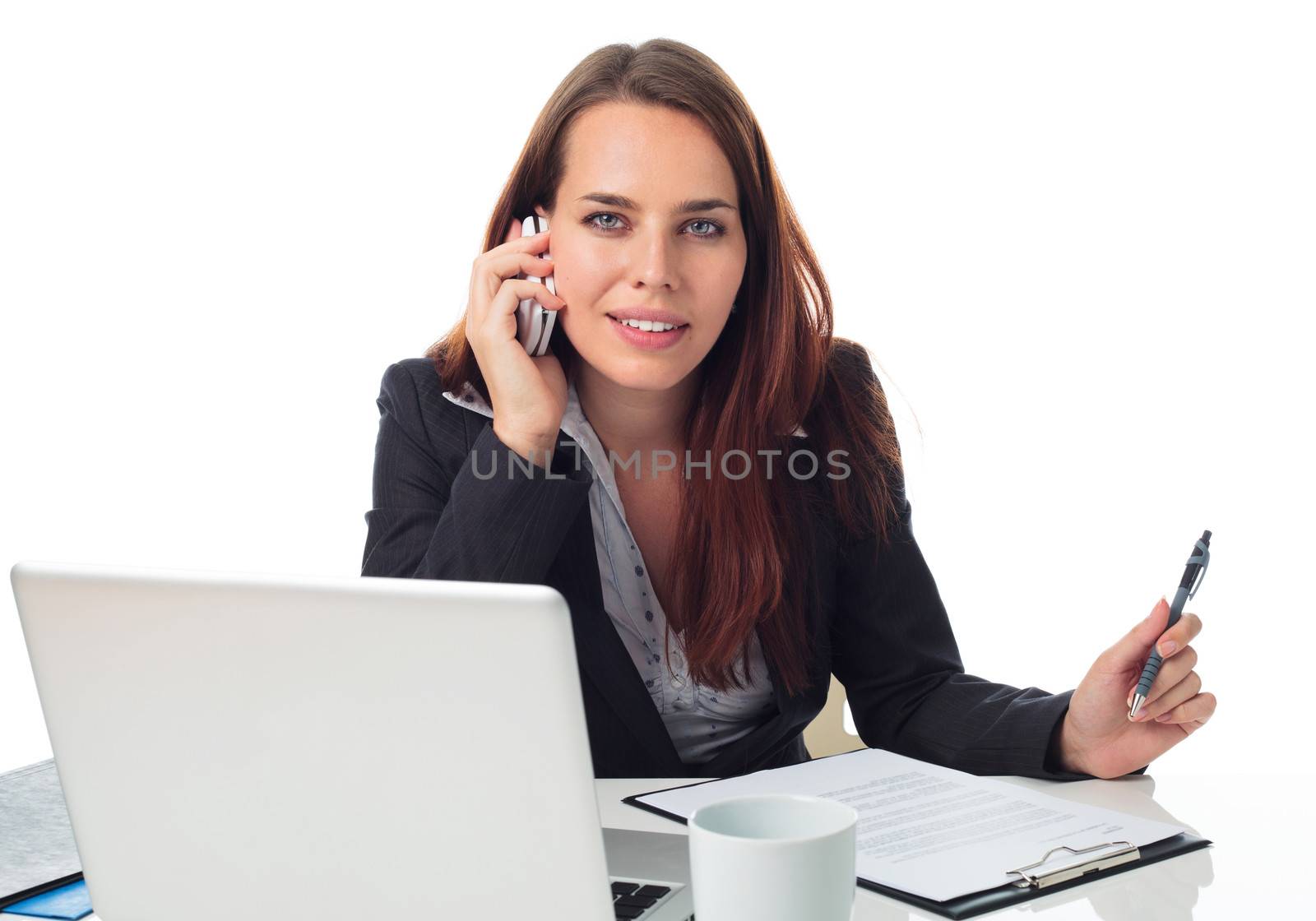 Beautiful business woman on the phone, working in front a laptop, isolated on white 