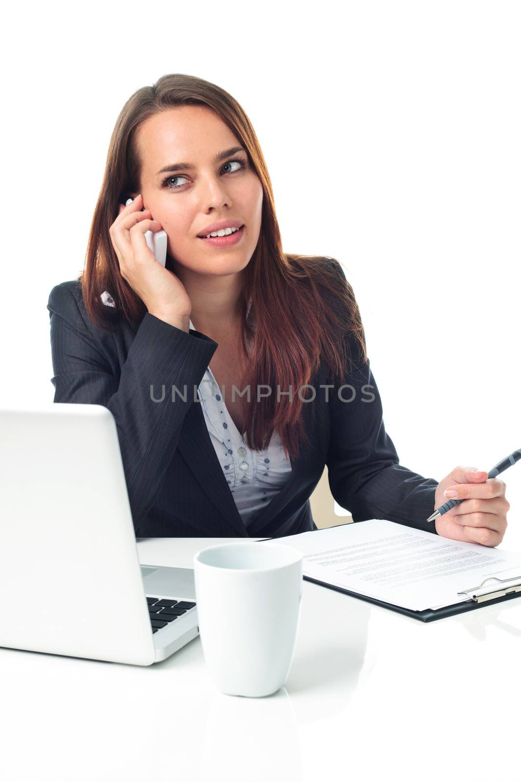 Pretty business woman on the phone, working in front a laptop, isolated on white 