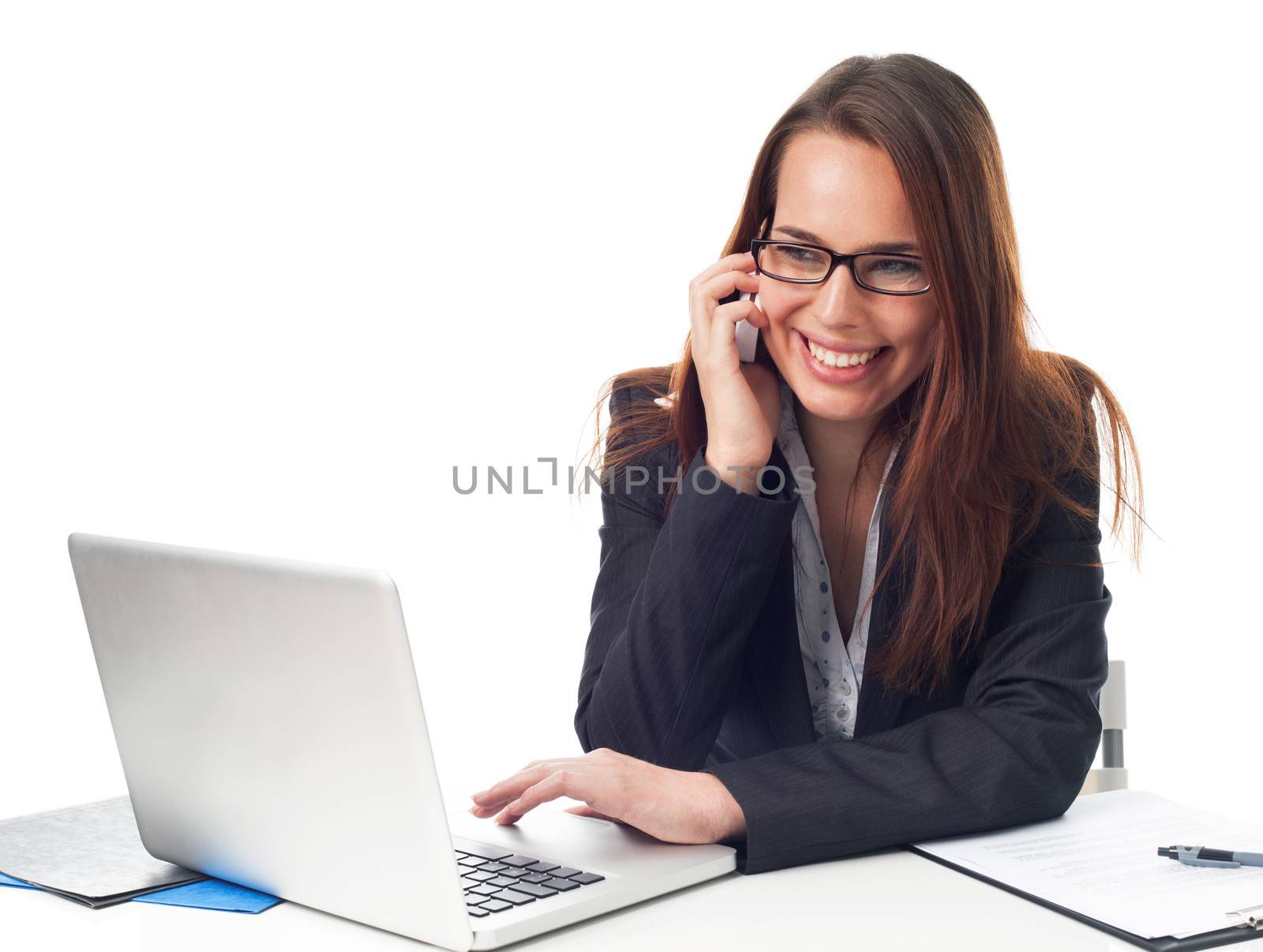 Happy business woman on the phone, working in front a laptop, isolated on white 