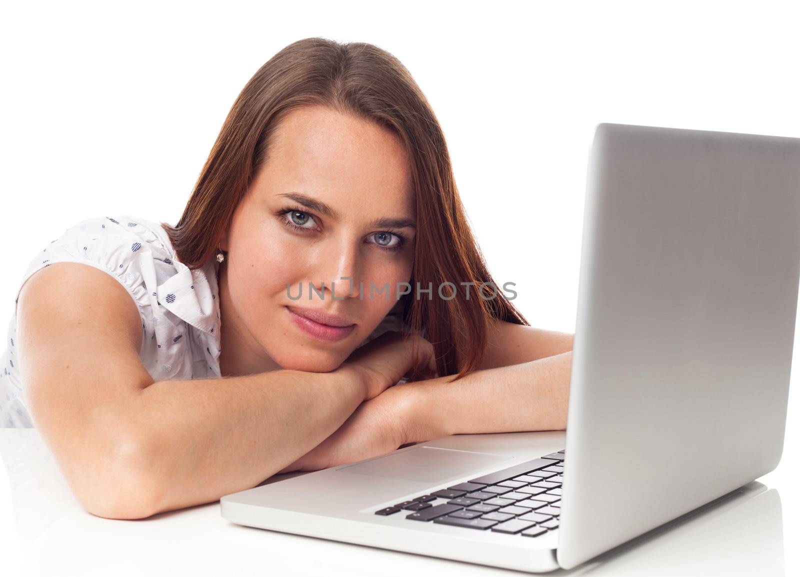 Beautiful young woman phoning, working in front a laptop, isolated on white 