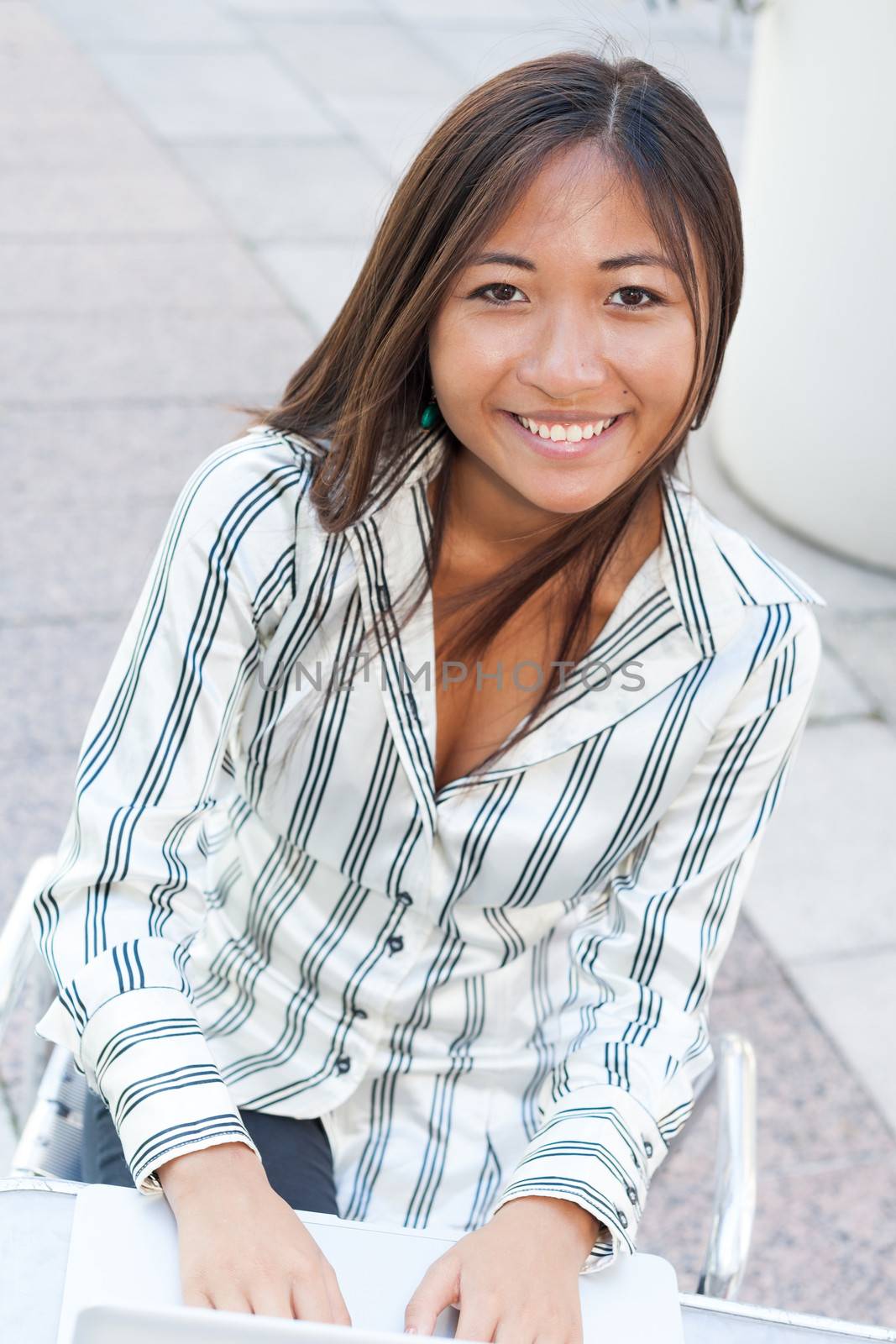 Cute asian woman writing on laptop by TristanBM