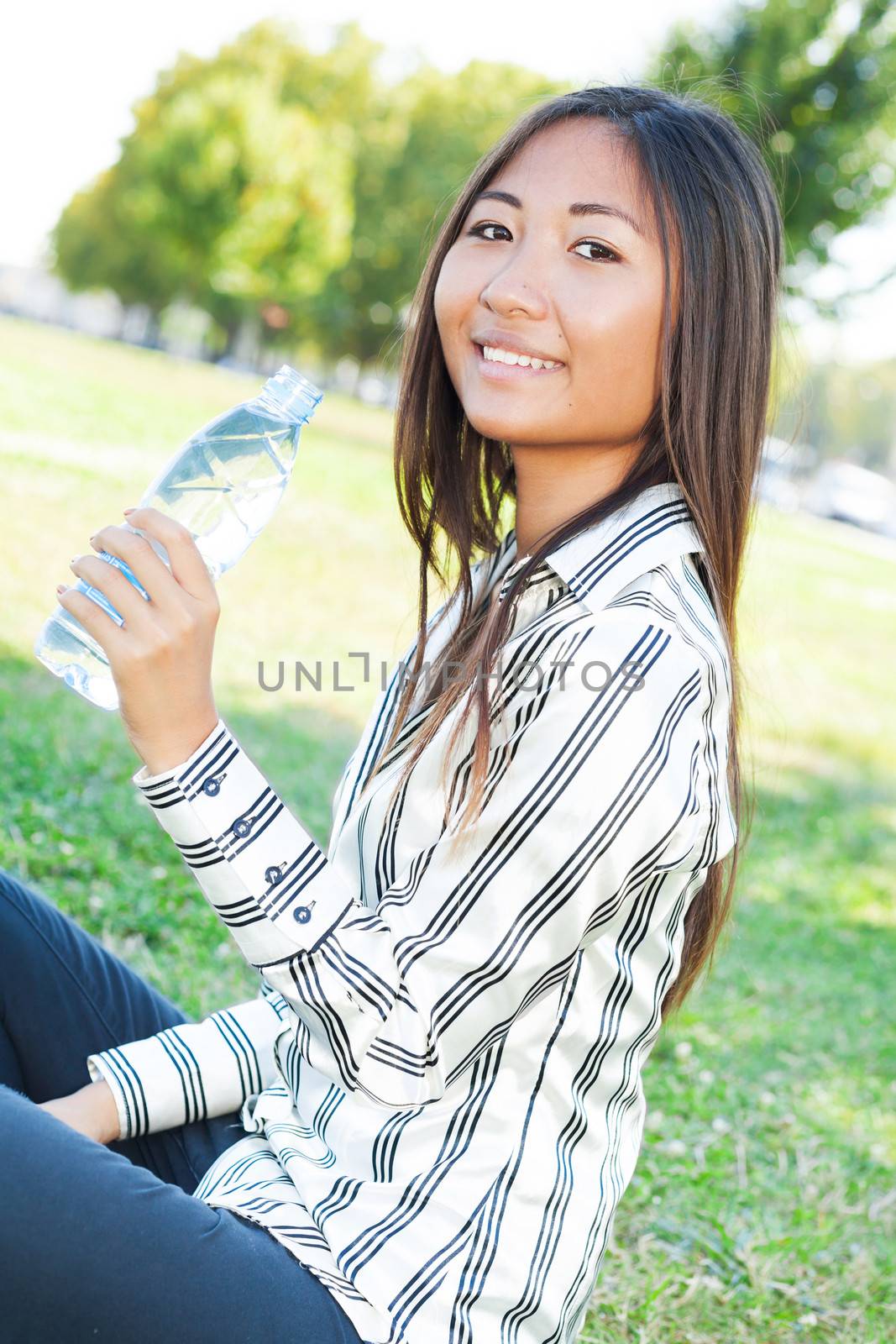 Asian girl drinking water in a park by TristanBM