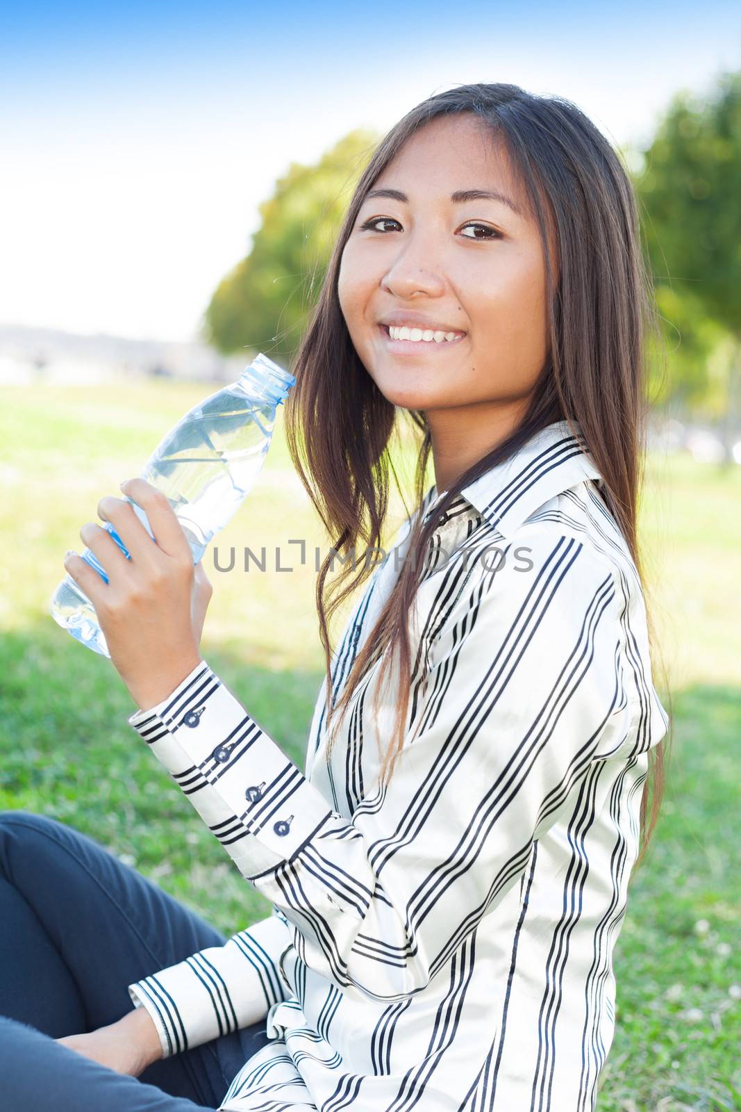 Pretty asian girl drinking water in a park by TristanBM