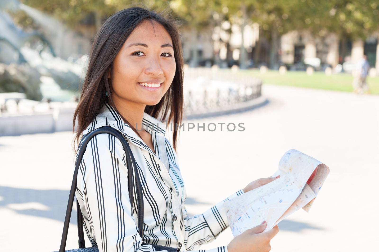 Beautiful asian tourist holding and reading city tour map