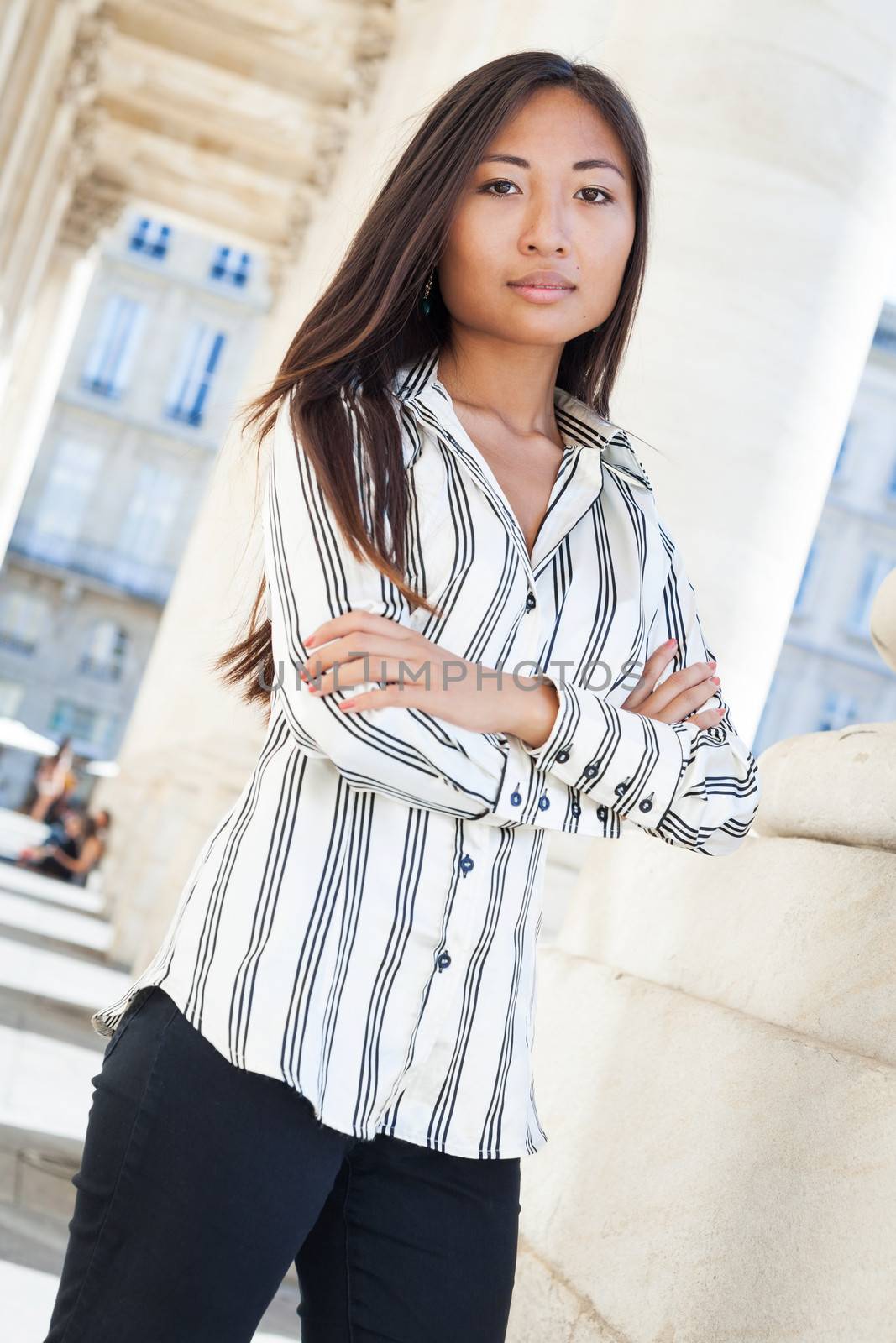 Portrait of a nice asian woman standing with arms crossed and smiling to the camera