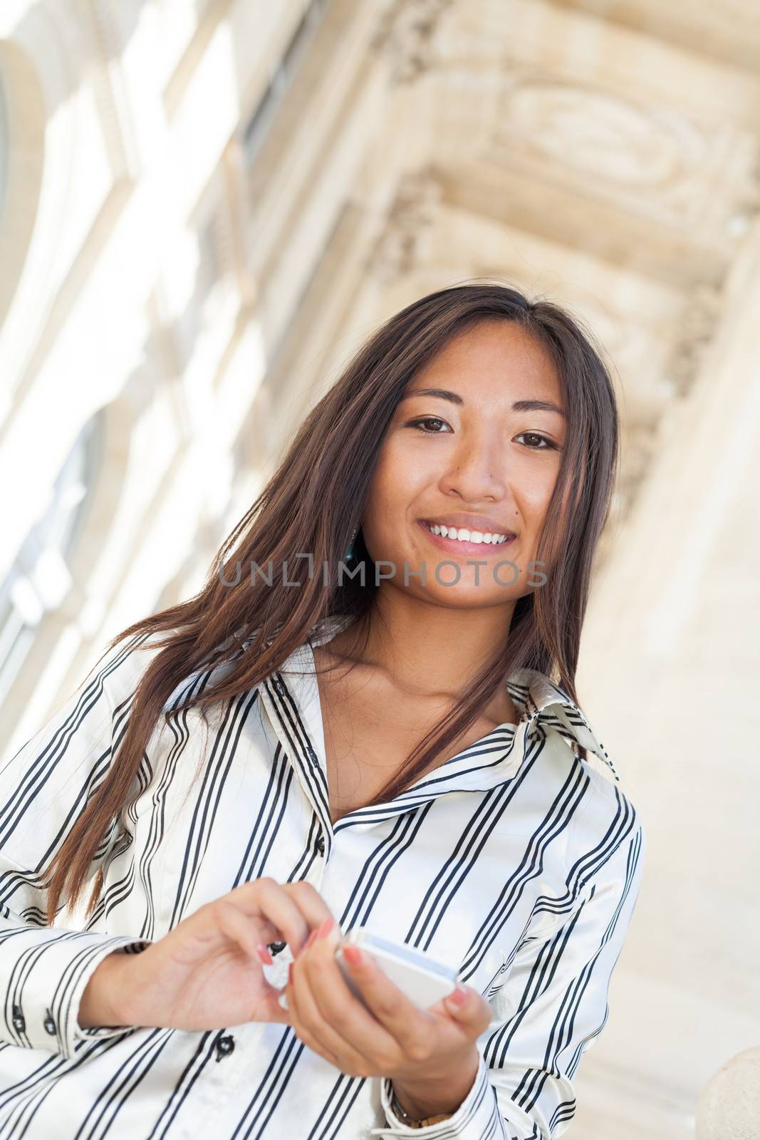 Beautiful asian girl smiling and using smart phone