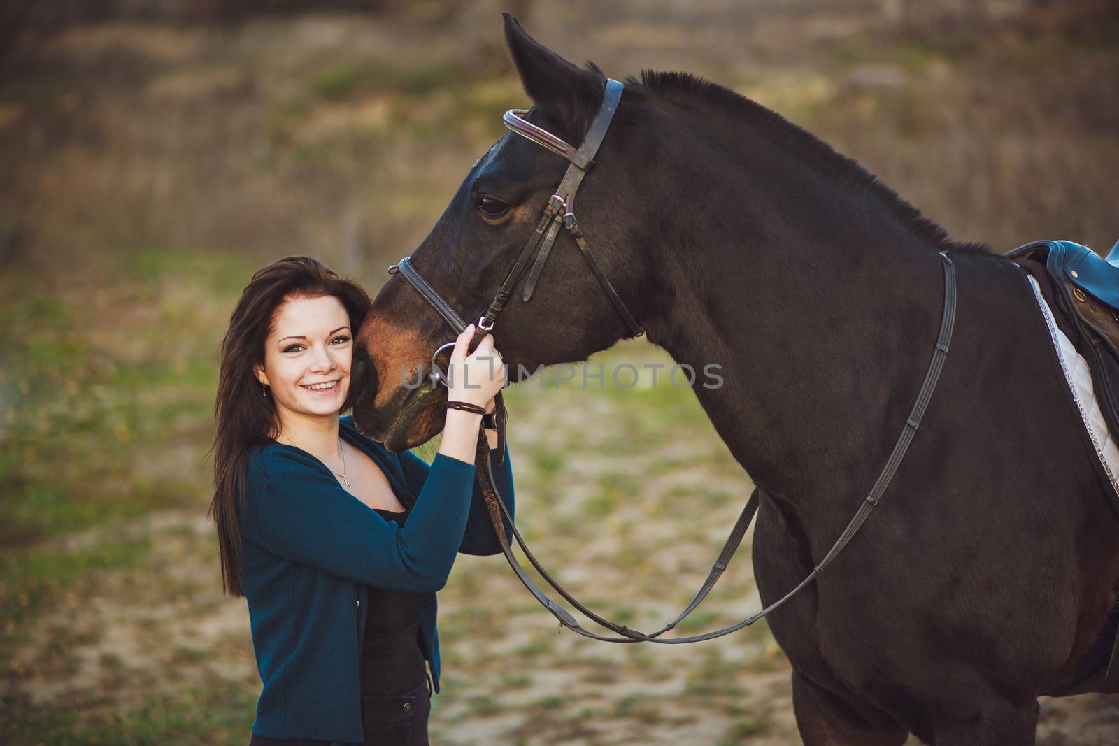 Young woman with a horse on nature