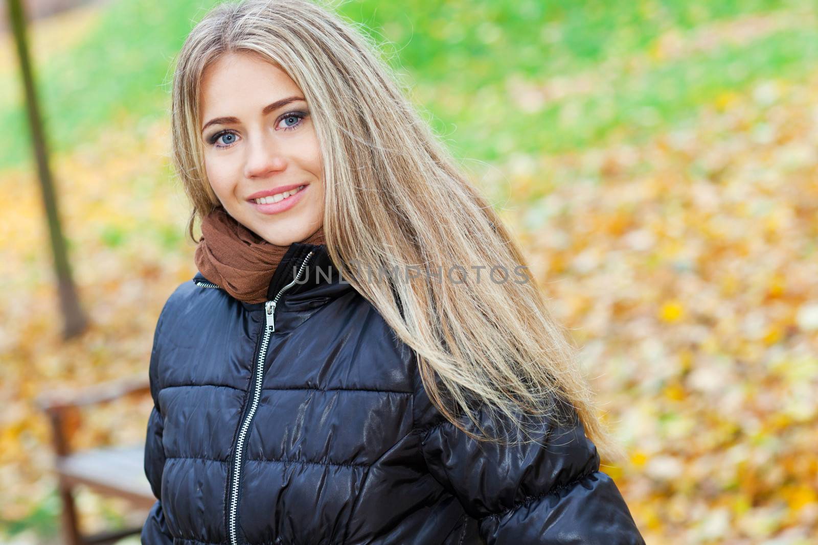 Pretty smiling woman walking in a park in autumn