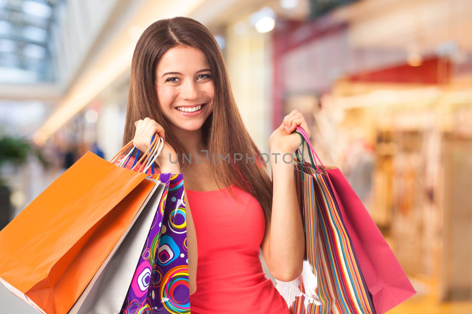 Portrait of a pretty young woman holding shopping bags in a supermarket