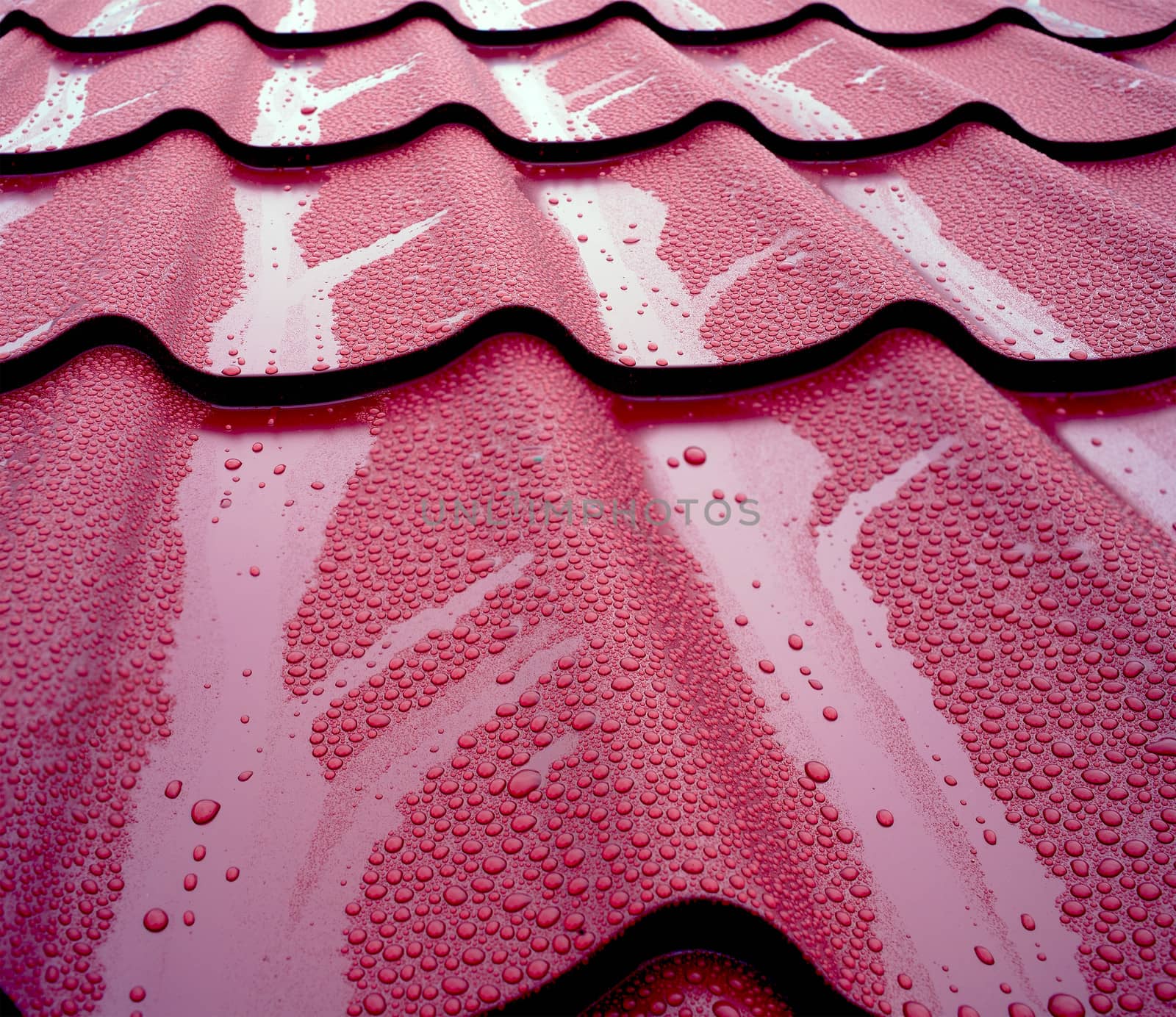 General view of wet metal roof shingles, protecting house from rain and mud