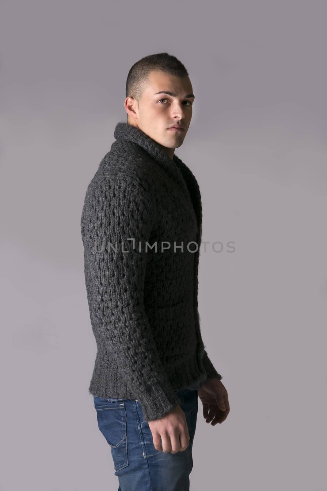 Attractive young man with wool sweater and jeans by artofphoto