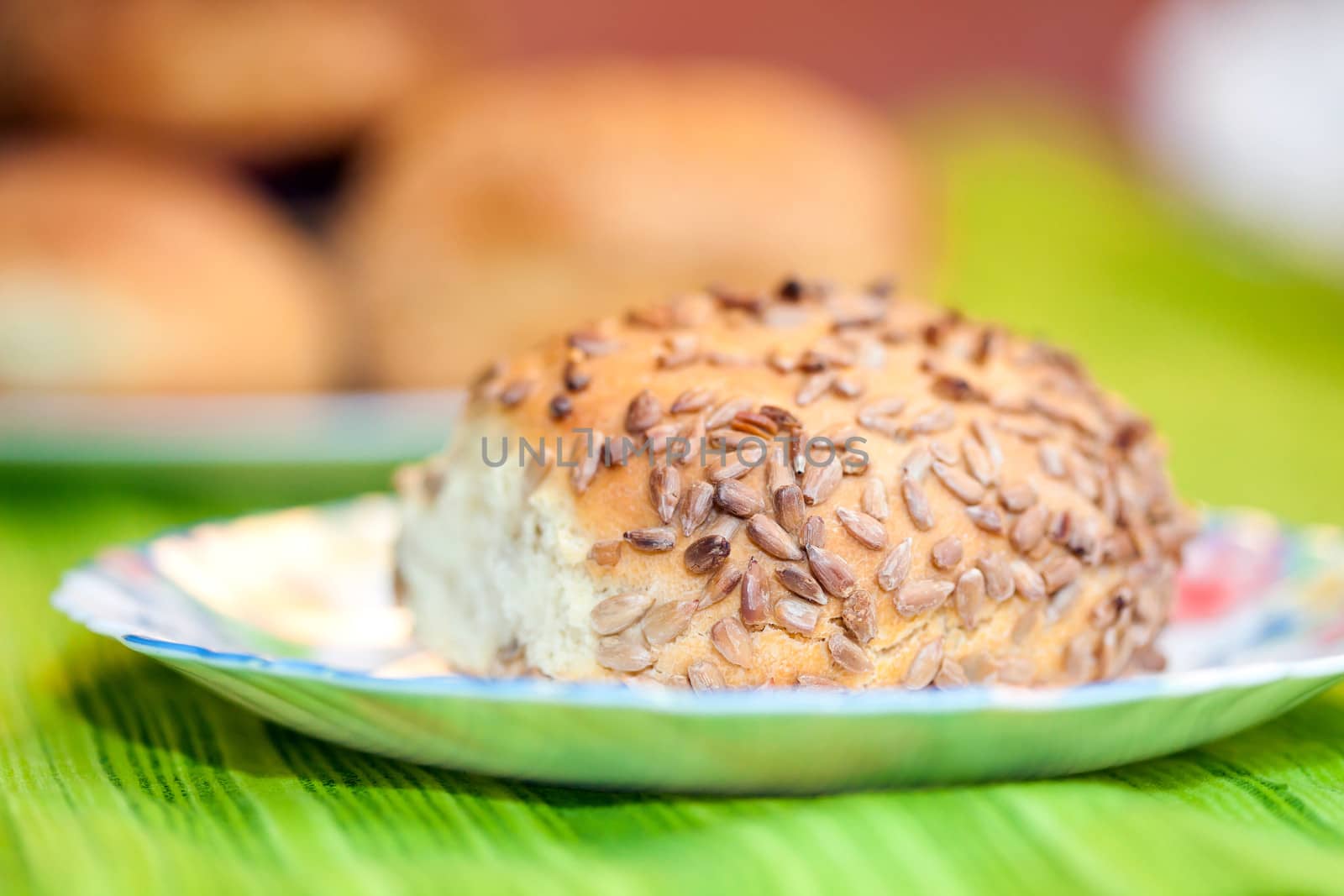 Fresh bread rolls with sunflower and sesame seeds on white plate table set