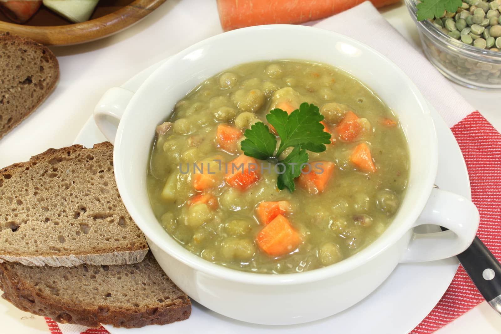 a white cup with pea soup and parsley