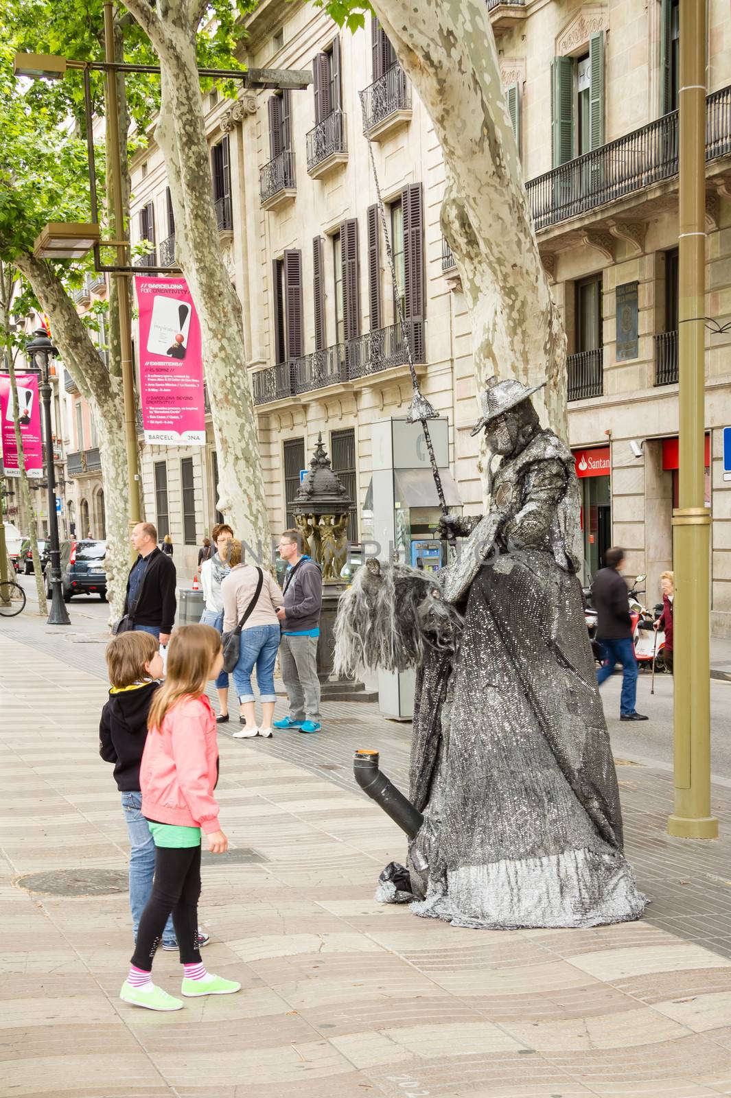 BARCELONA, SPAIN - MAY 31 Childs looking a street artist in the famous and touristic La Rambla street, in Barcelona, Spain, on May 31, 2013