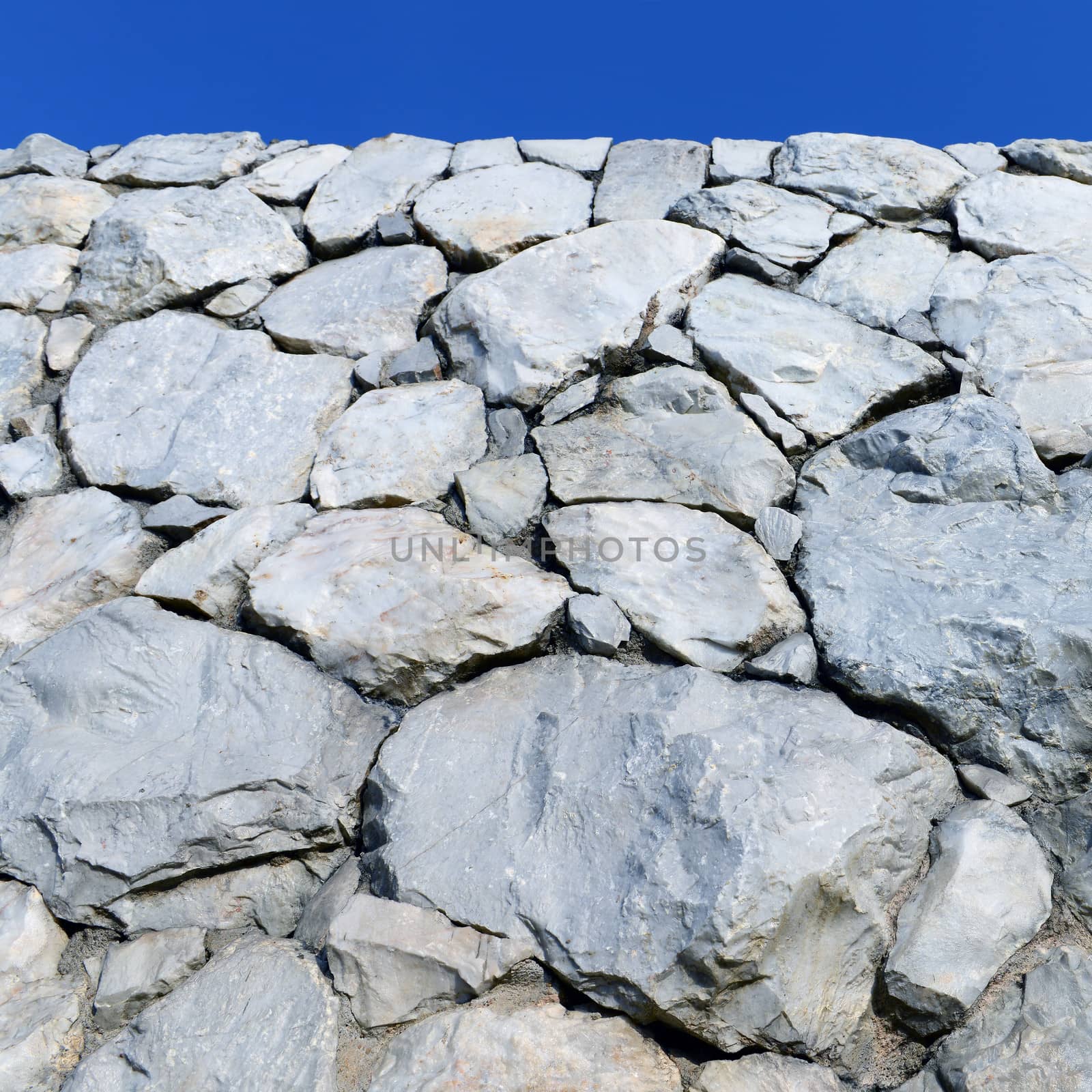 Stone wall with blue sky  by opasstudio
