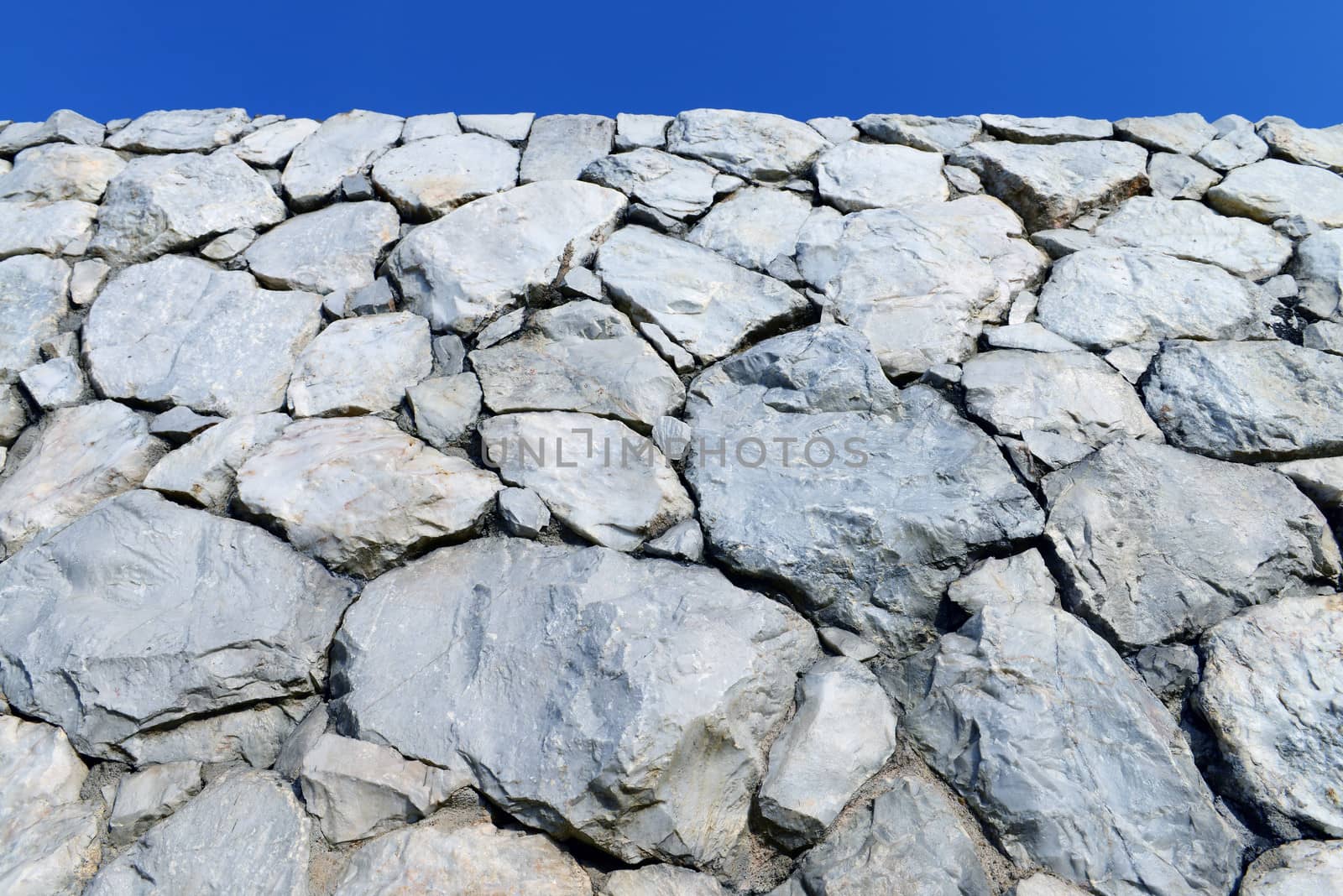 Stone wall with blue sky  by opasstudio