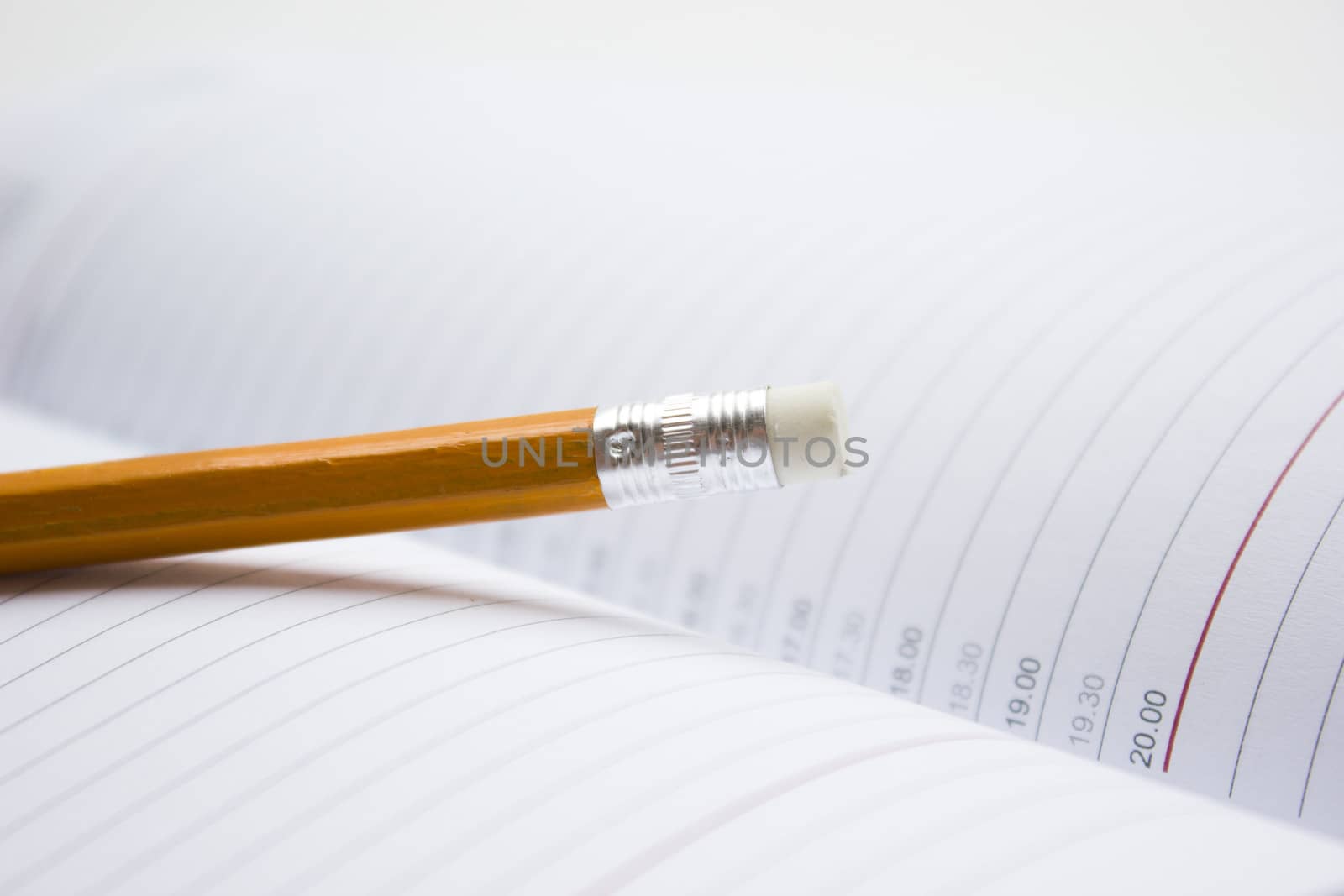 Pencil in a composition with a blank book with hardcovers.