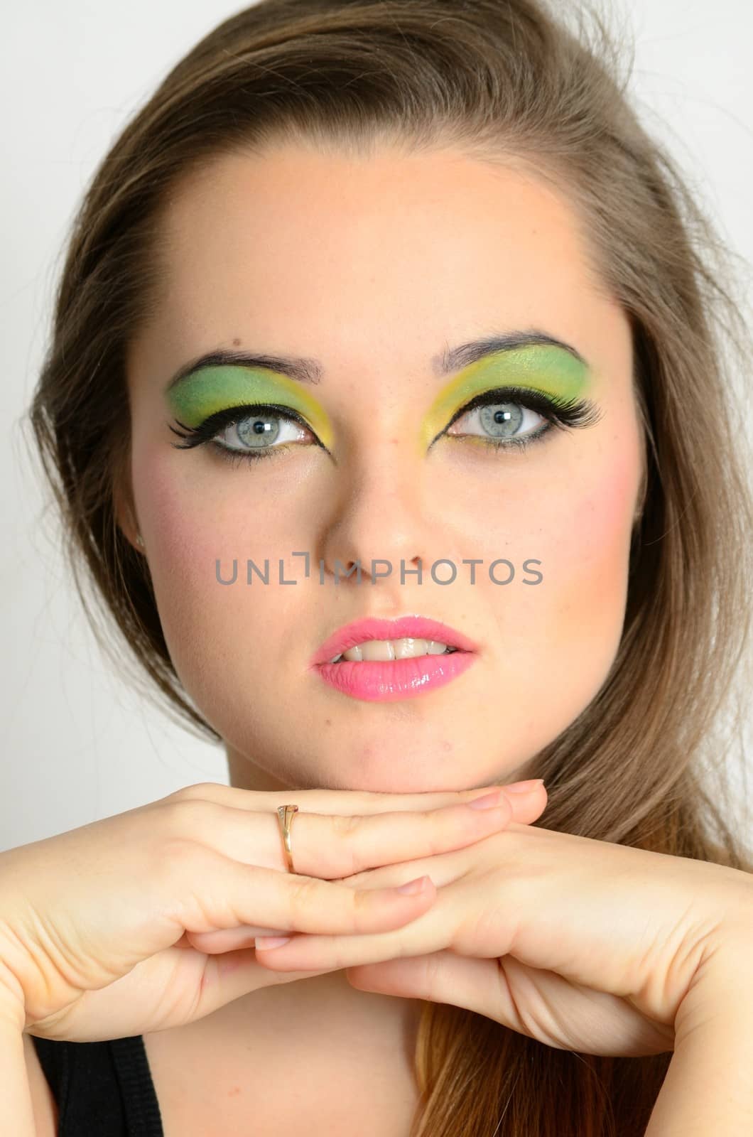 Young female model with colorful makeup. Face closeup portrait photo of teenager. 