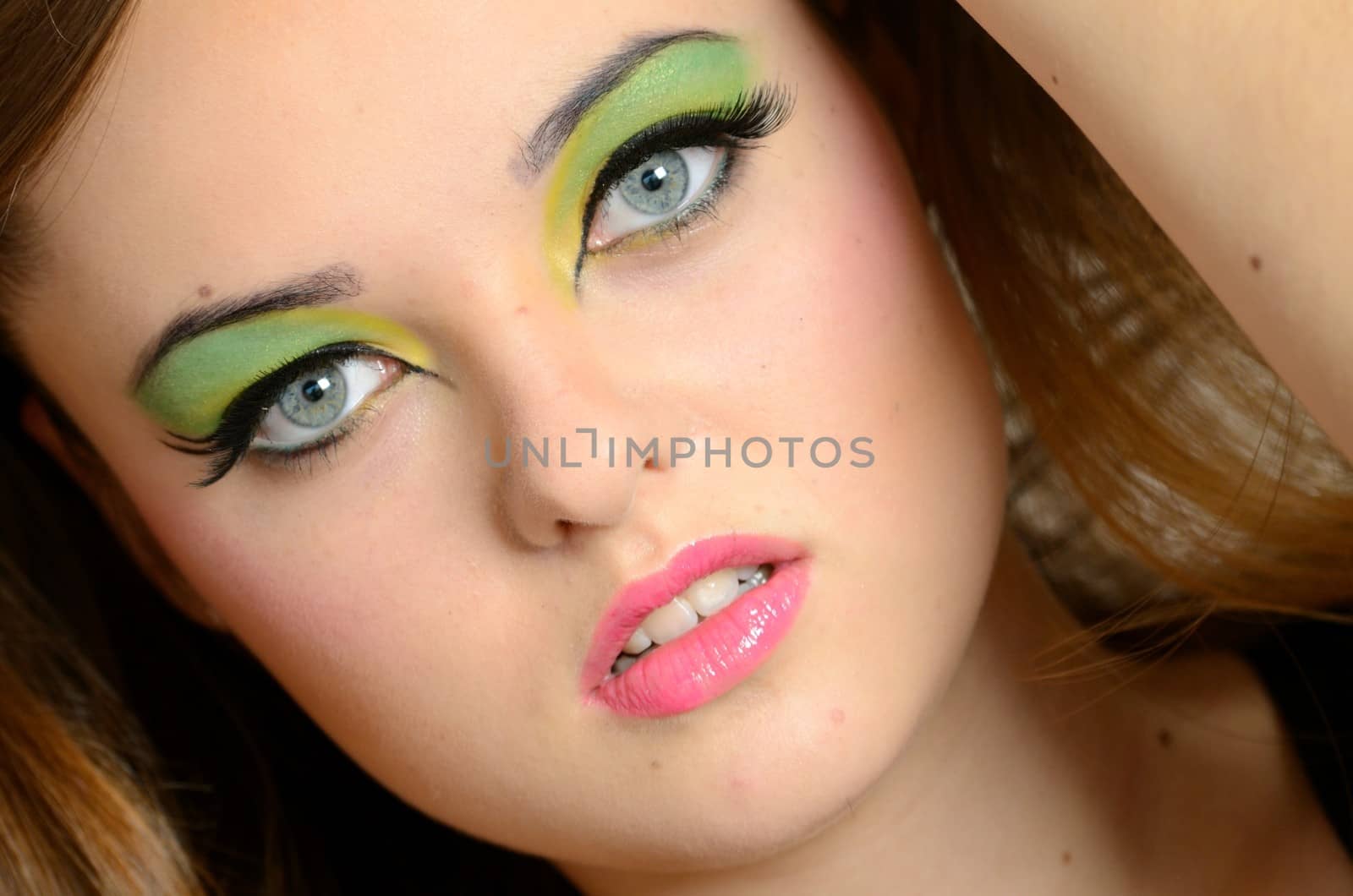 Close face portrait of young female. Polish teenager with colorful makeup.