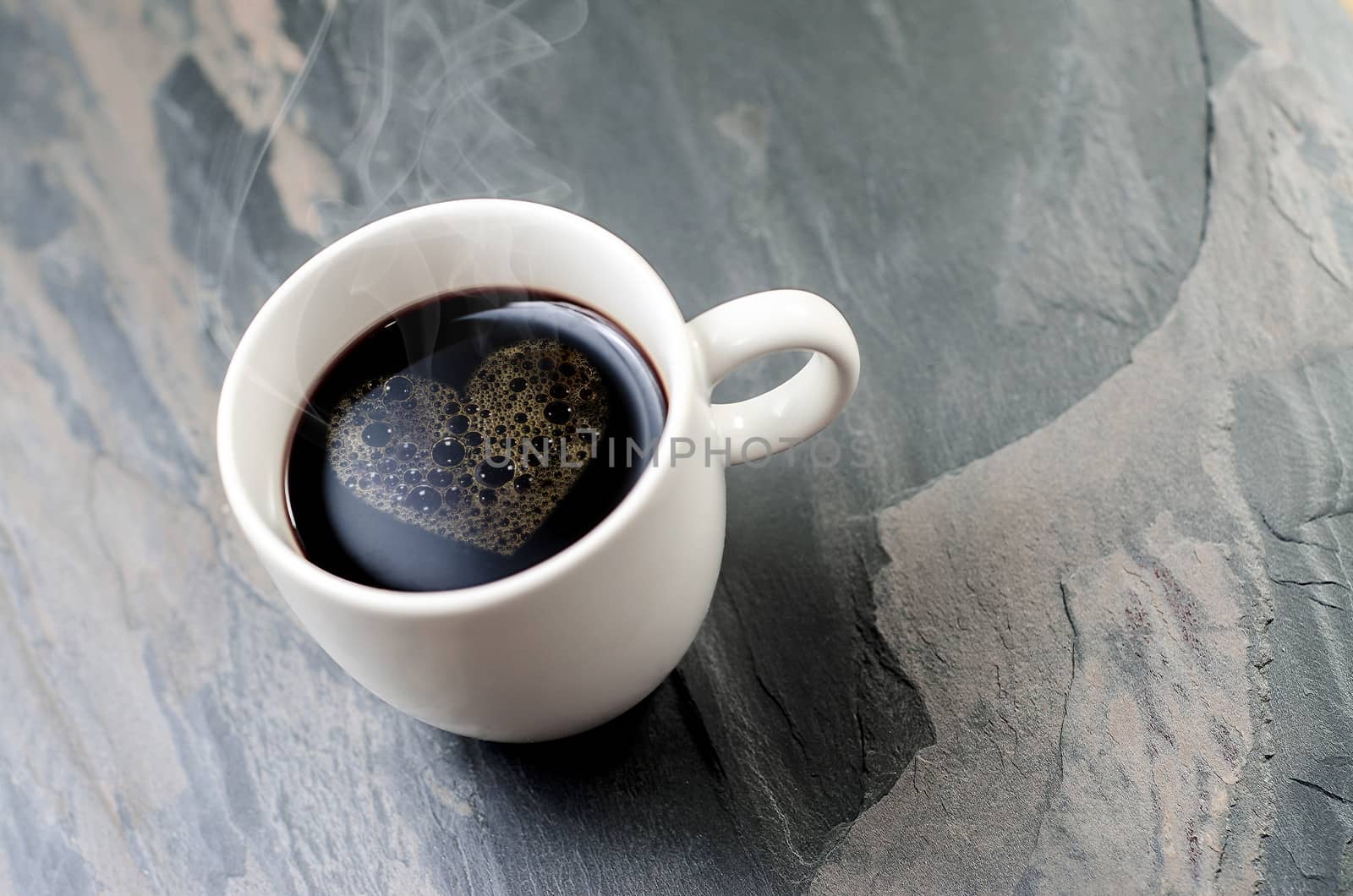 cup coffee with heart symbol on a stone table  background 