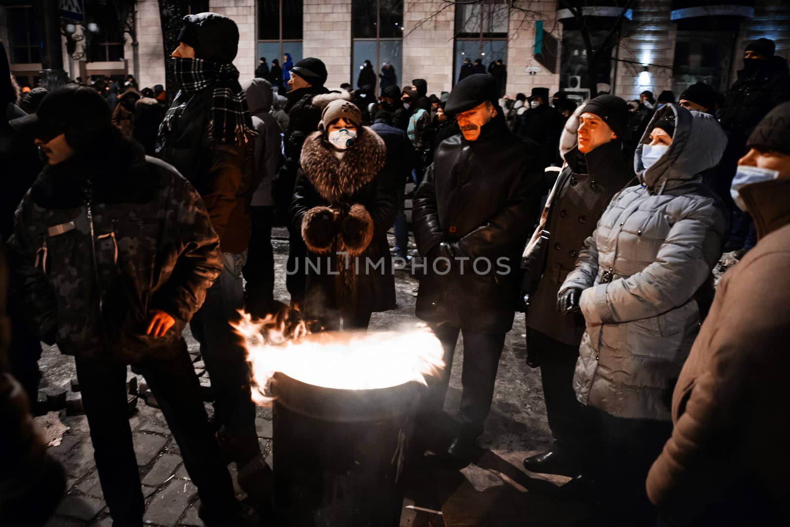 KIEV, UKRAINE - January 20, 2014: Mass anti-government protests in the center of the Ukrainian capital Kiev. Members of the Popular Resistance basking near the fire  on Hrushevskoho St.