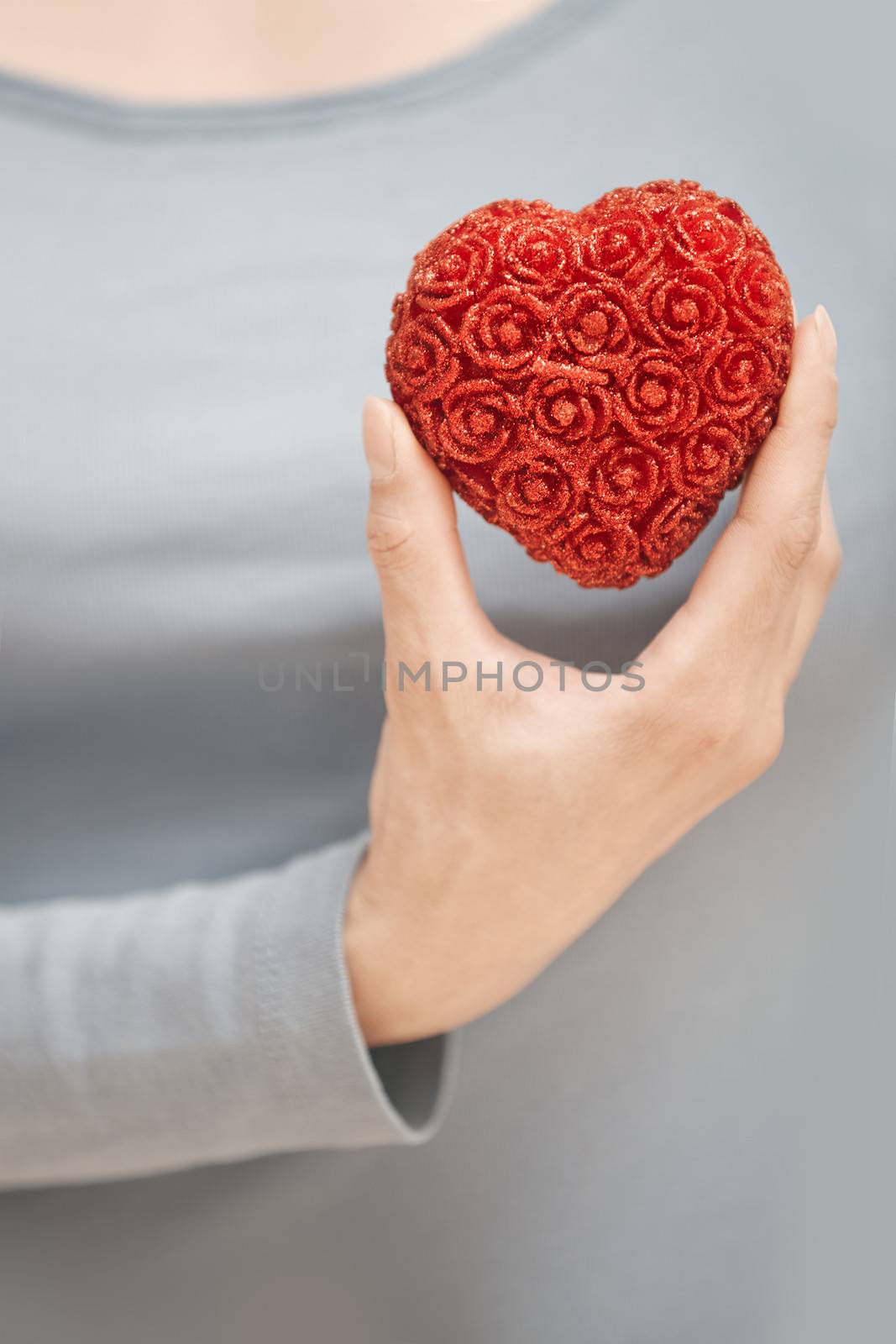 Woman hand holding heart as a symbol of love