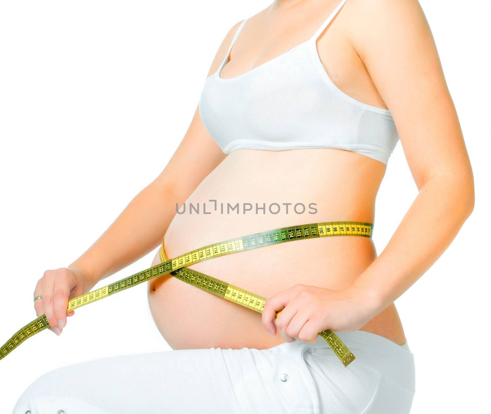young pregnant woman measuring belly on a white background