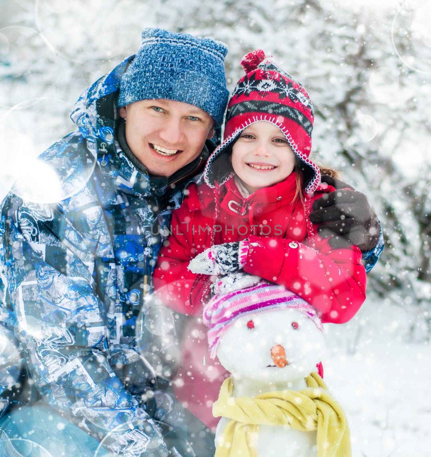 Father and daughter making a snowman