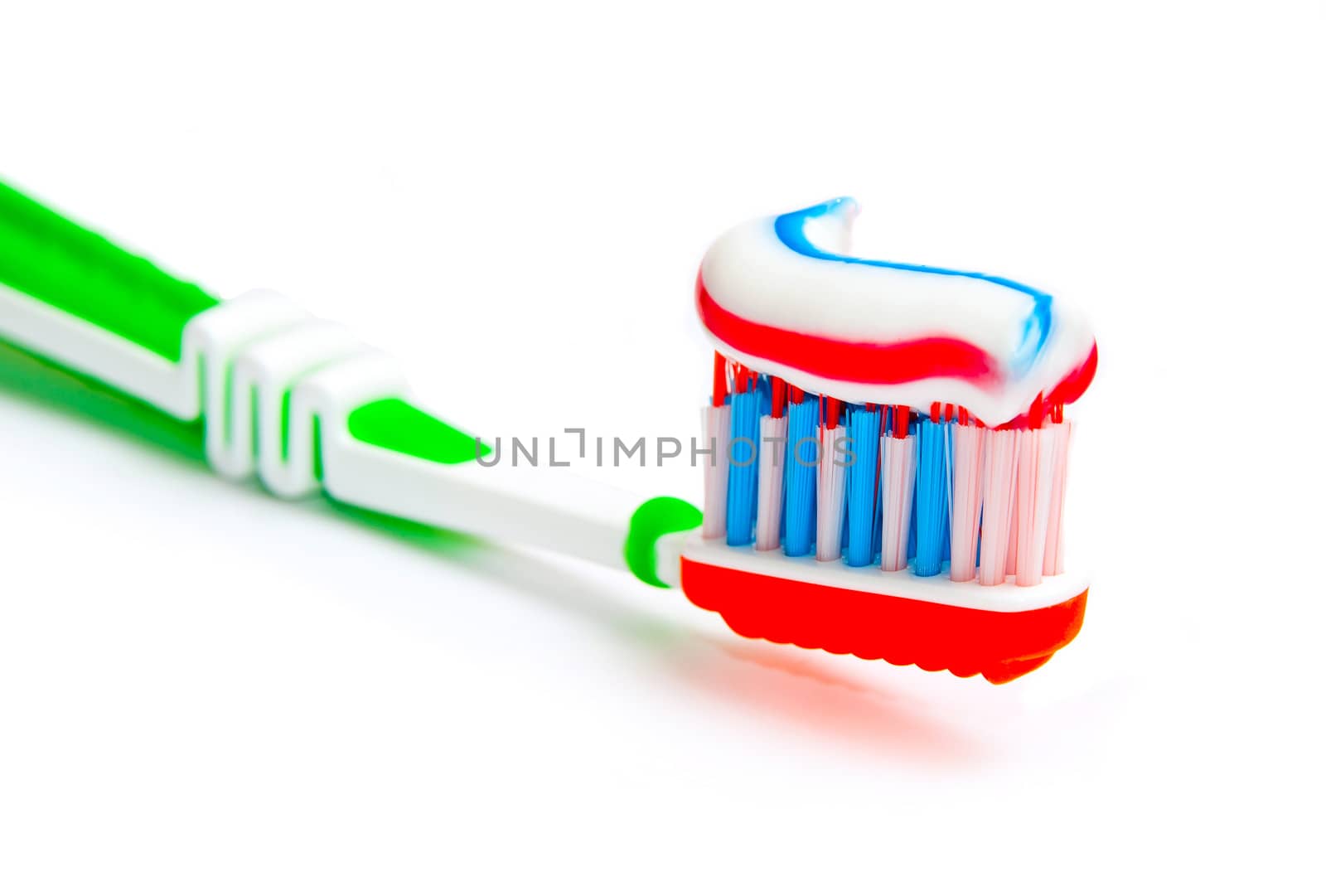 toothbrush with tricolor toothpaste isolated on a white background