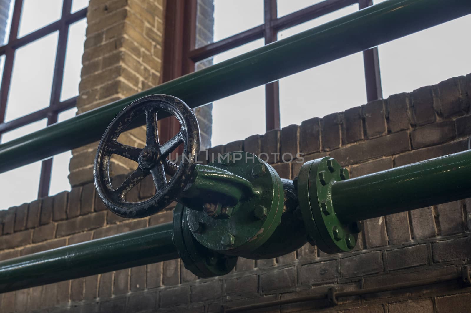 green manual valve in green metal tube in industrial building