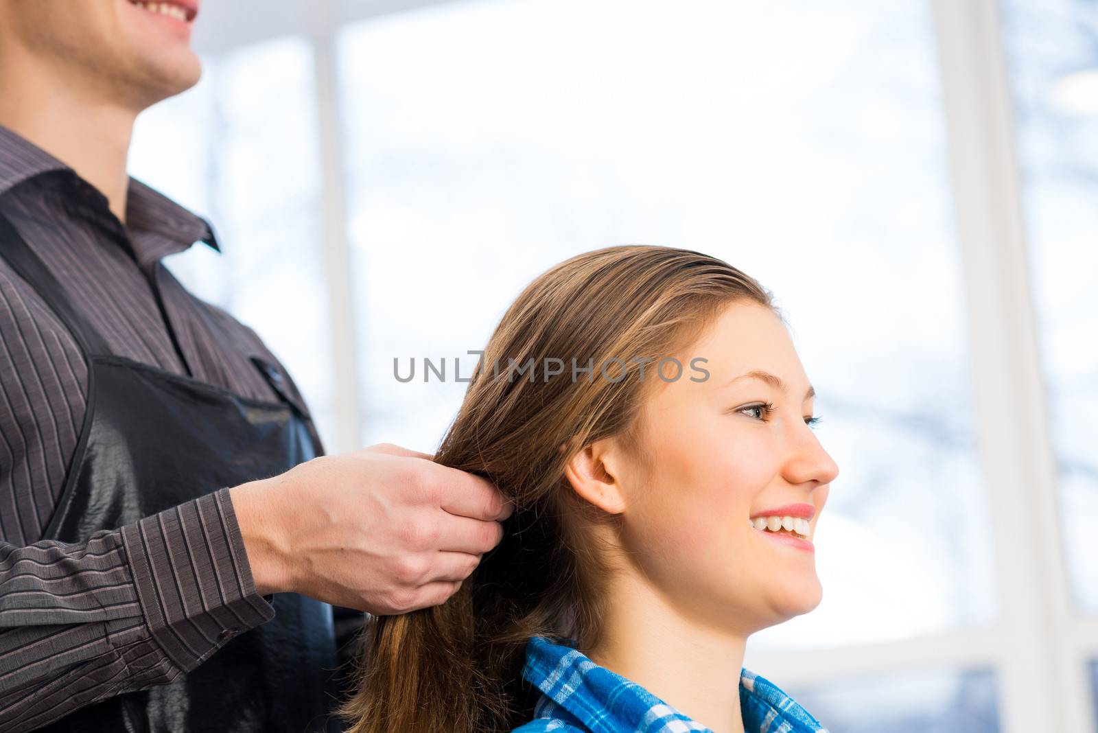 male hairdresser puts woman's hair in a hairdressing salon