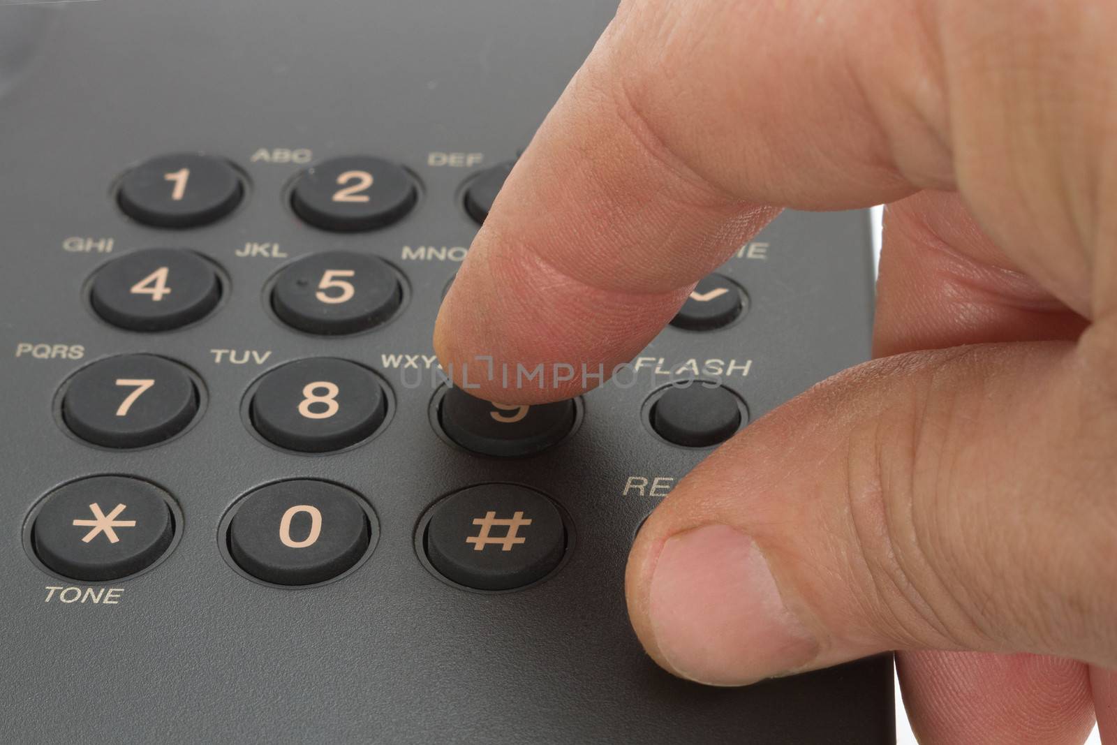 Dailing number on a black telephone, with finger pressing on the 9 button