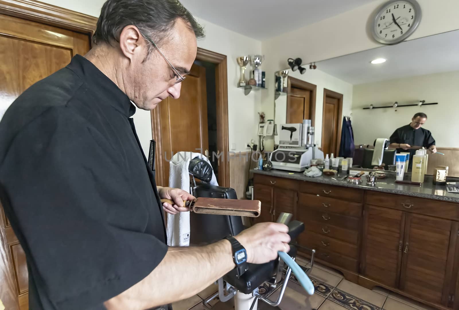 Barber sharpens razor old-fashioned in a barber's shop, Sabiote, Jaen province, Andalucia, Spain