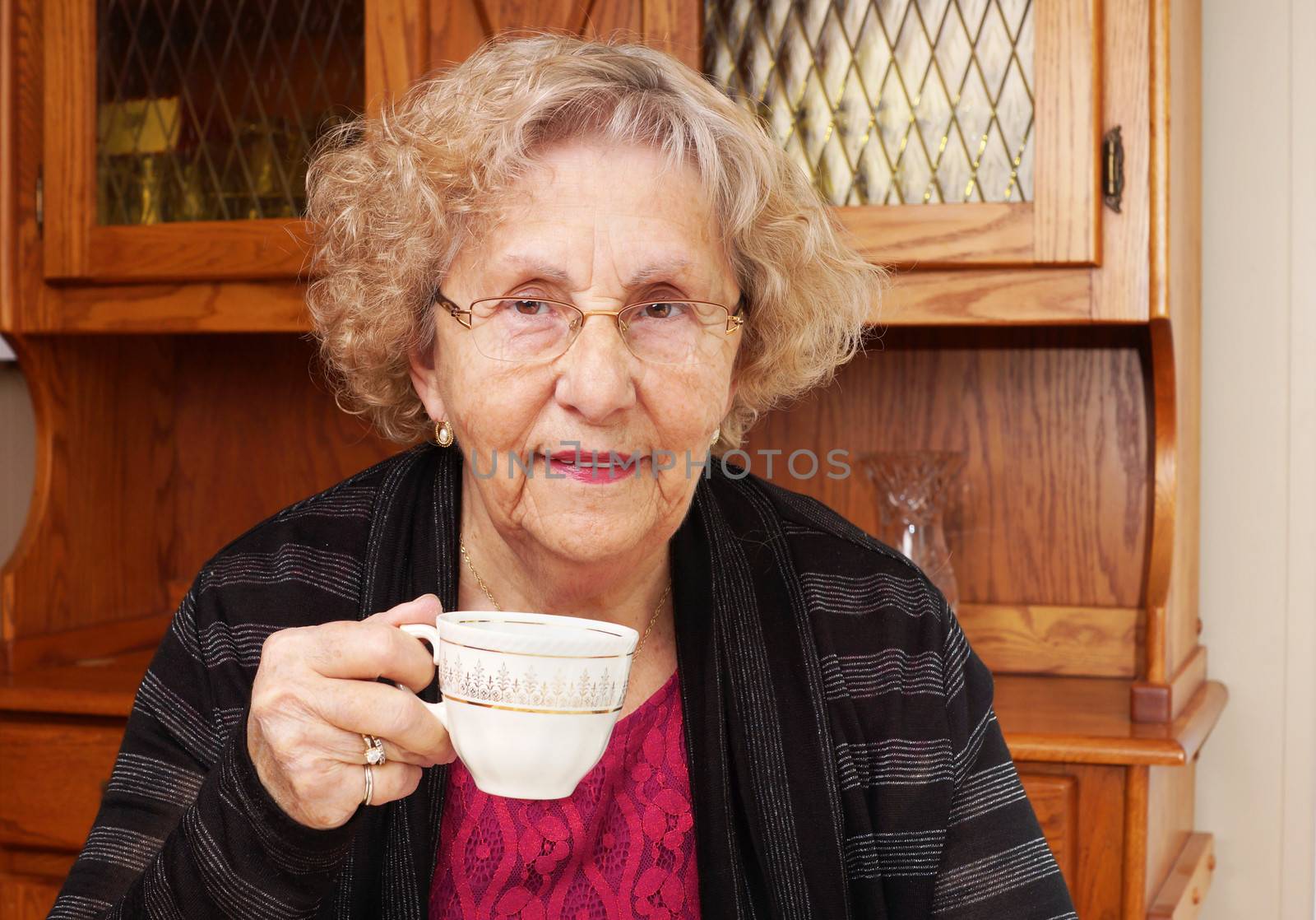 Happy senior woman drinking tea at home