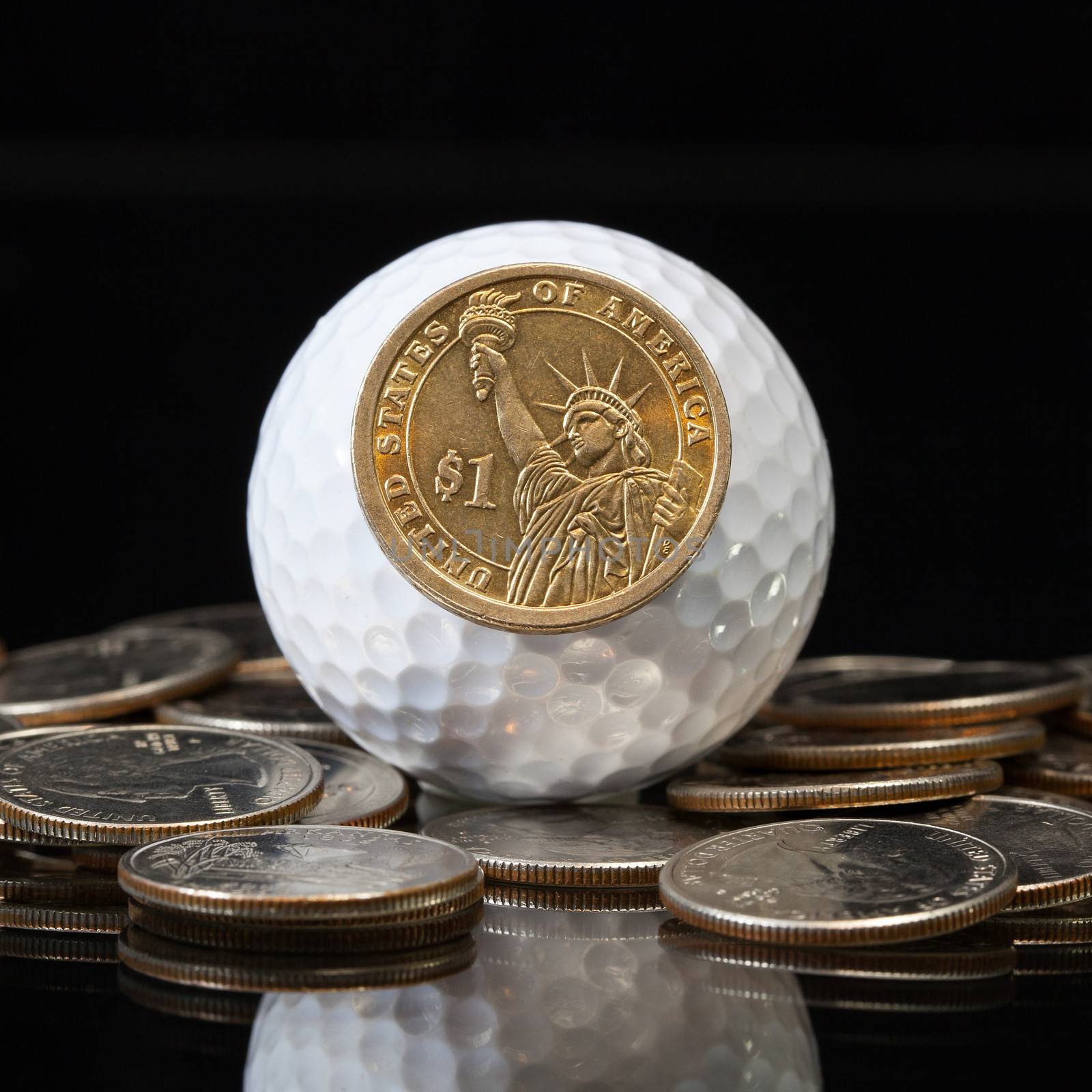 White golf ball and different U.S. dollar coins