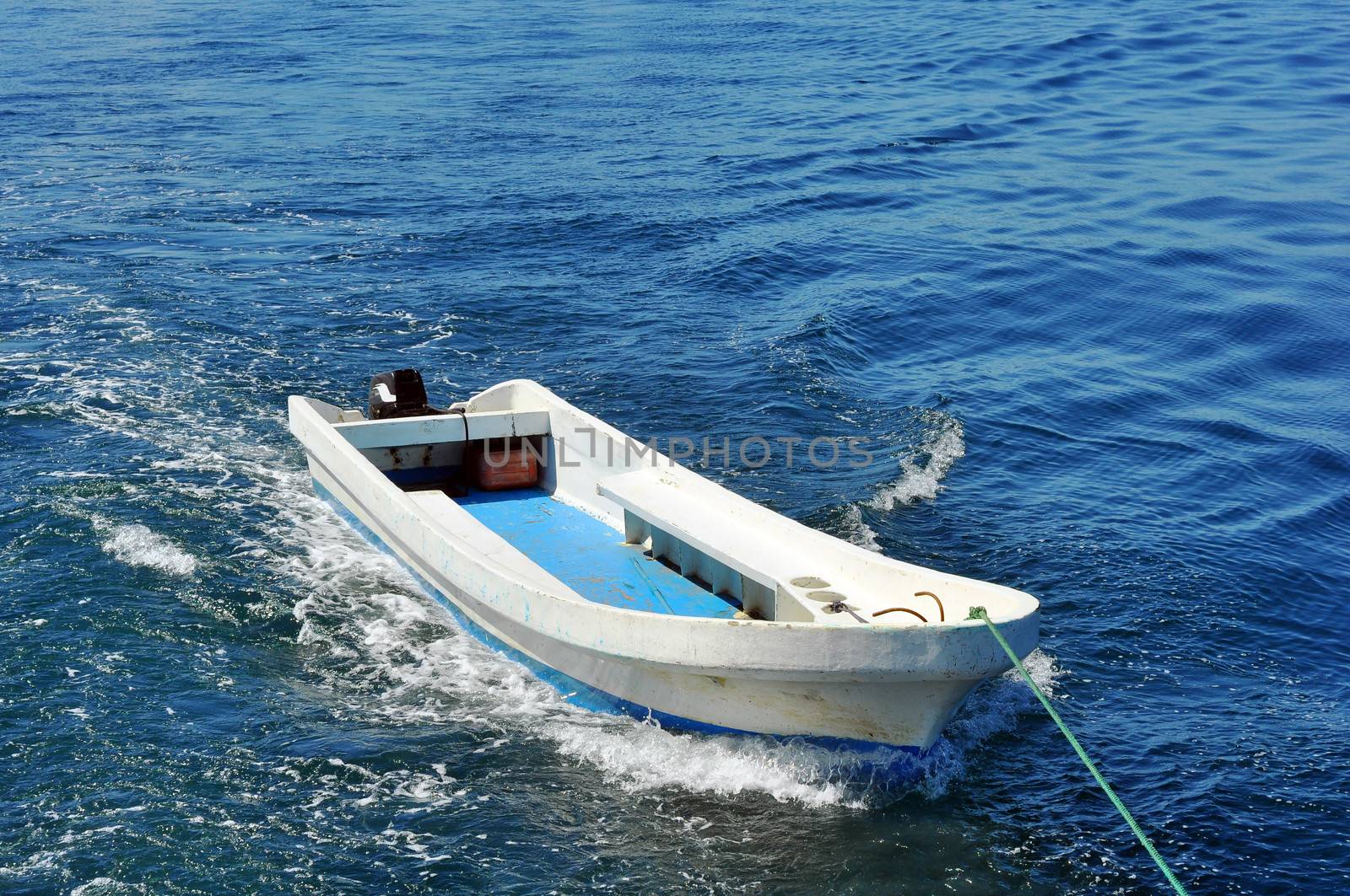 Small boat being towed on the blue tropical sea