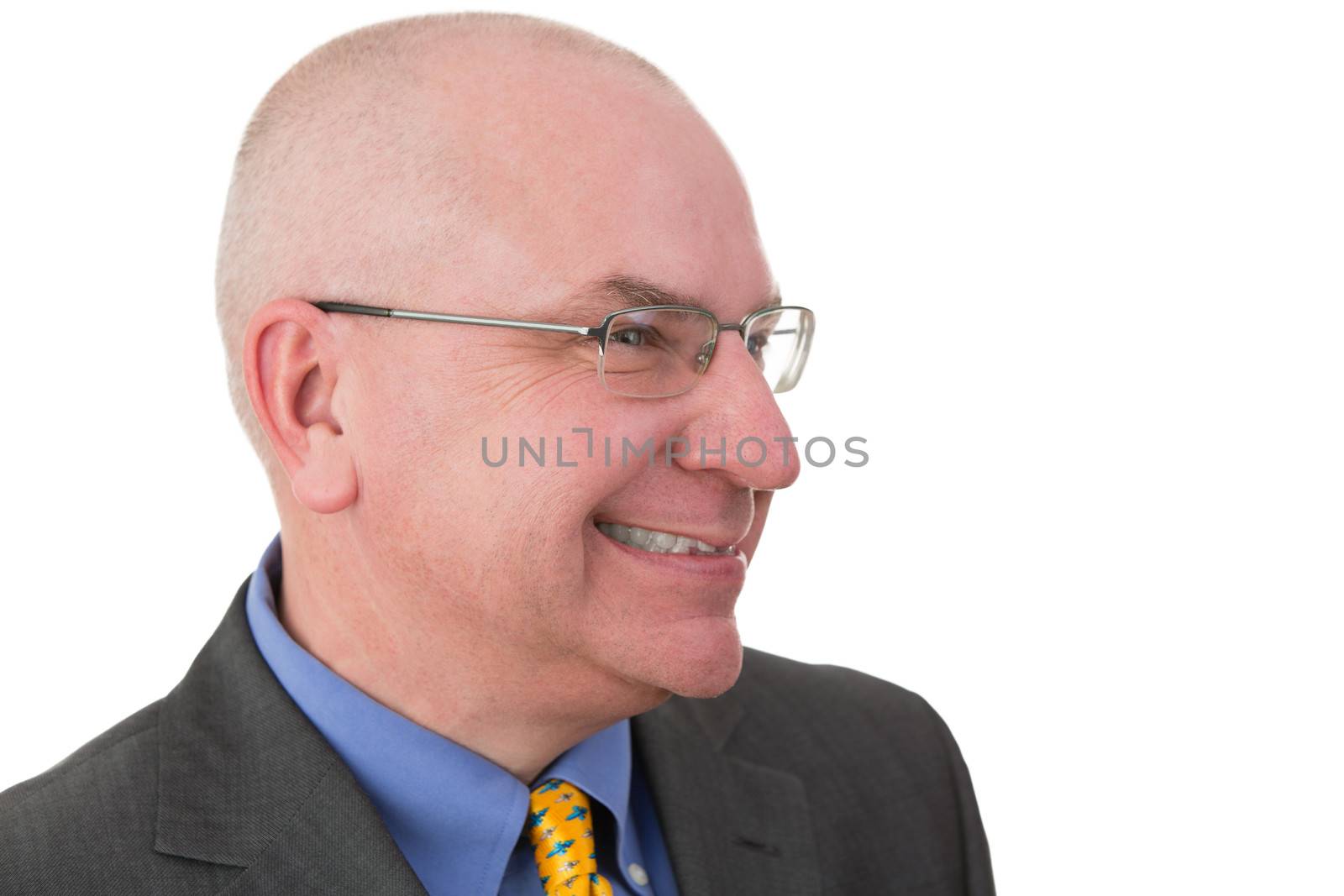 Middle-aged businessman giving a wry smile as he realises the irony of a situation, head and shoulders portrait on white with his head turned to the side