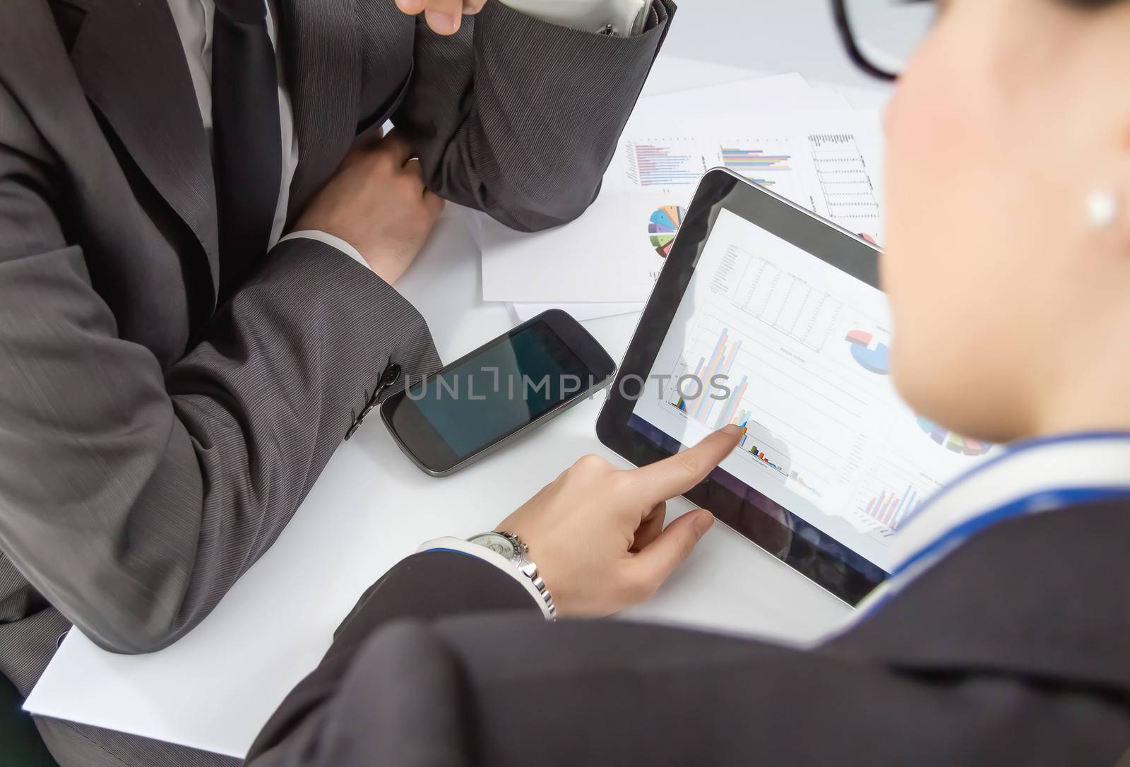 Businesswoman showing financial charts and documents in a digital tablet to the company boss