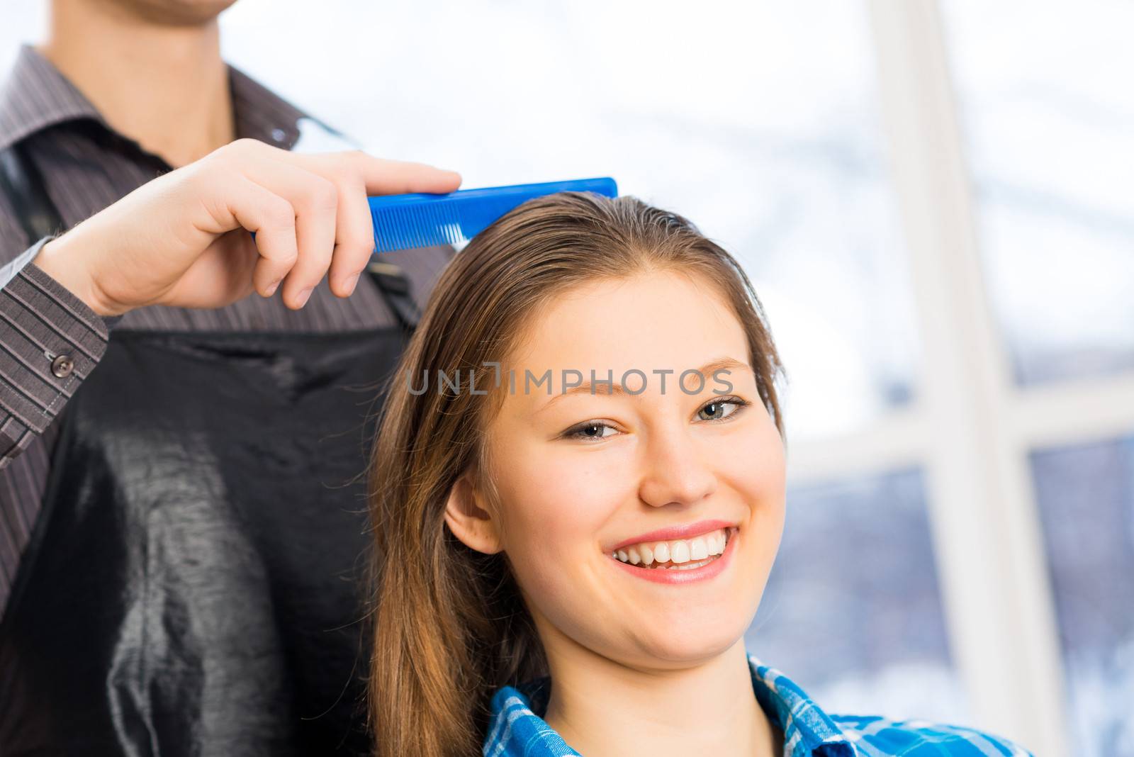 male hairdresser puts woman's hair in a hairdressing salon