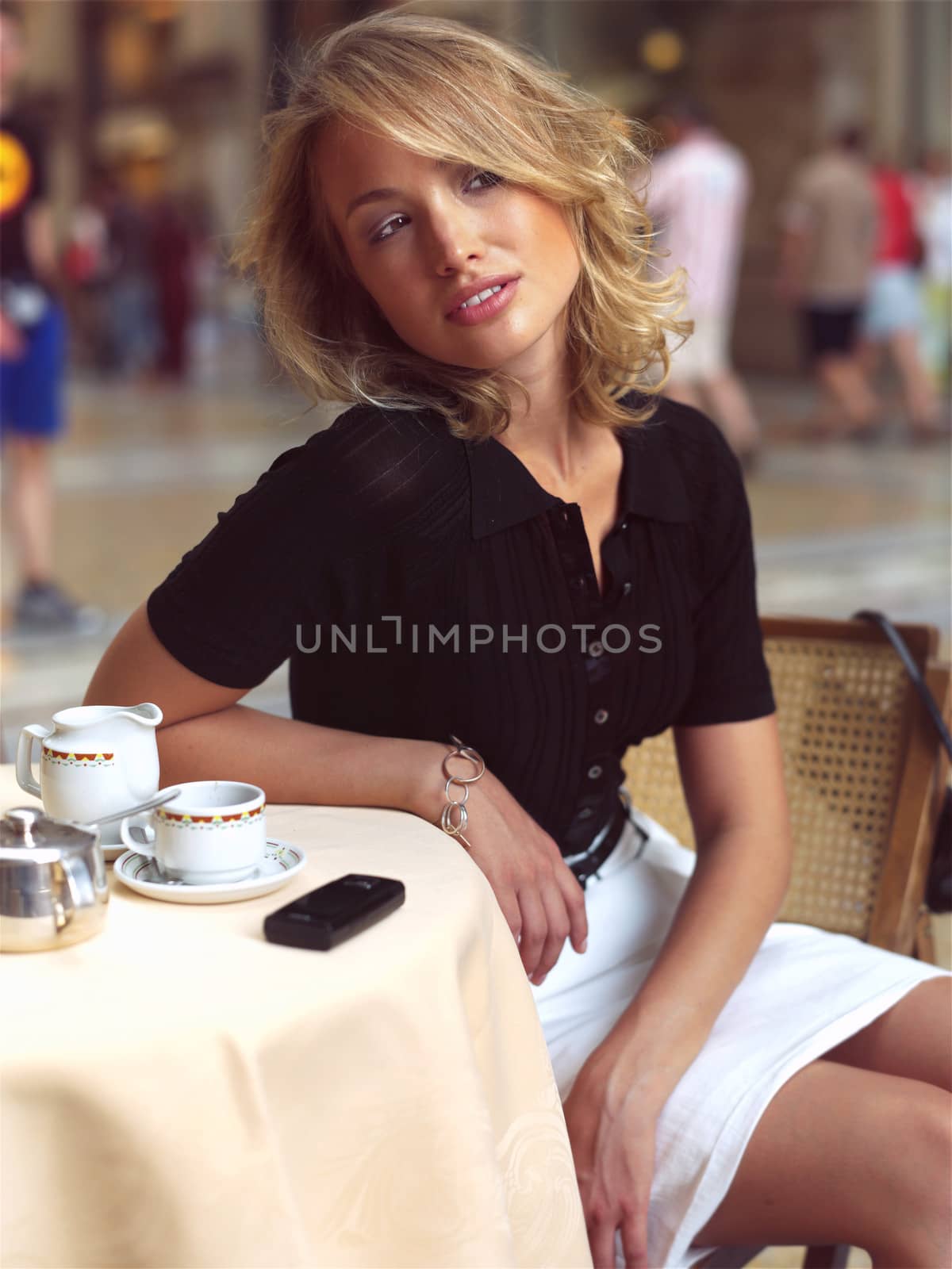 beautiful woman sitting in a Cafe and talking by mobile