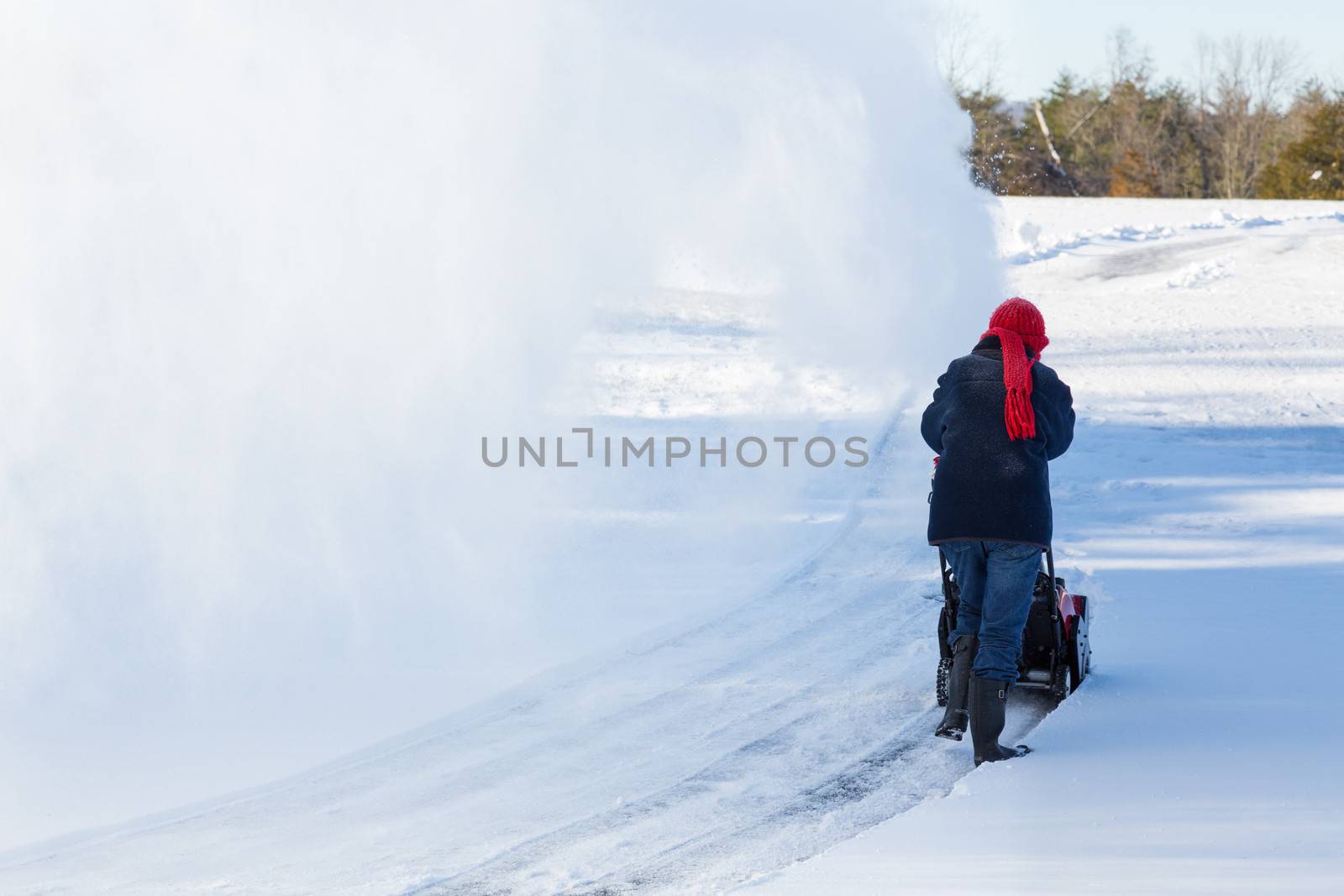 Senior woman clearing drive with snowblower by steheap