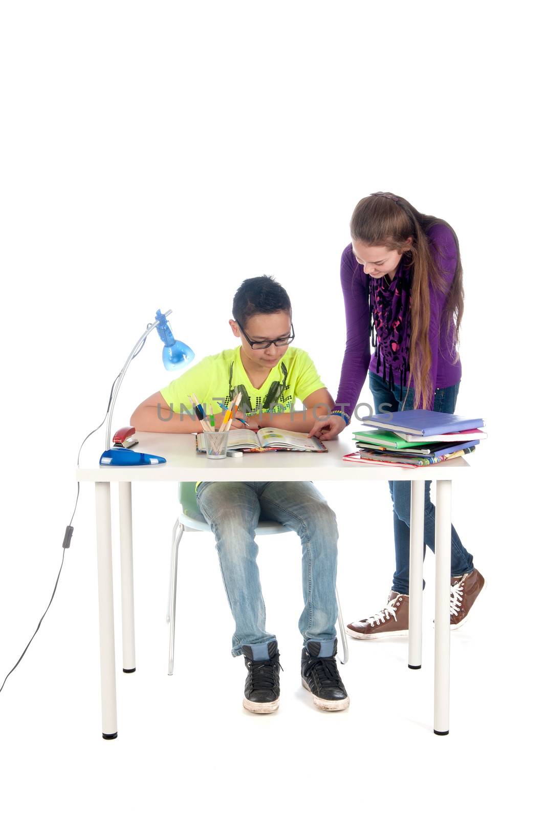 A teenage girl is helping a teenage boy with his homework