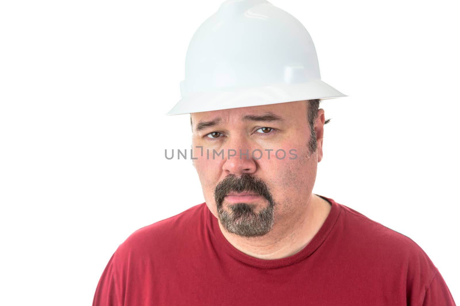 Thoughtful man wearing a hardhat staring at the camera with an uncertain analytical expression as he struggles to believe something that does not seem quite true, isolated on white