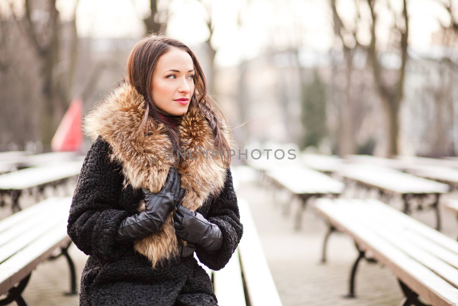 Young professional lady in the park is enjoying winter