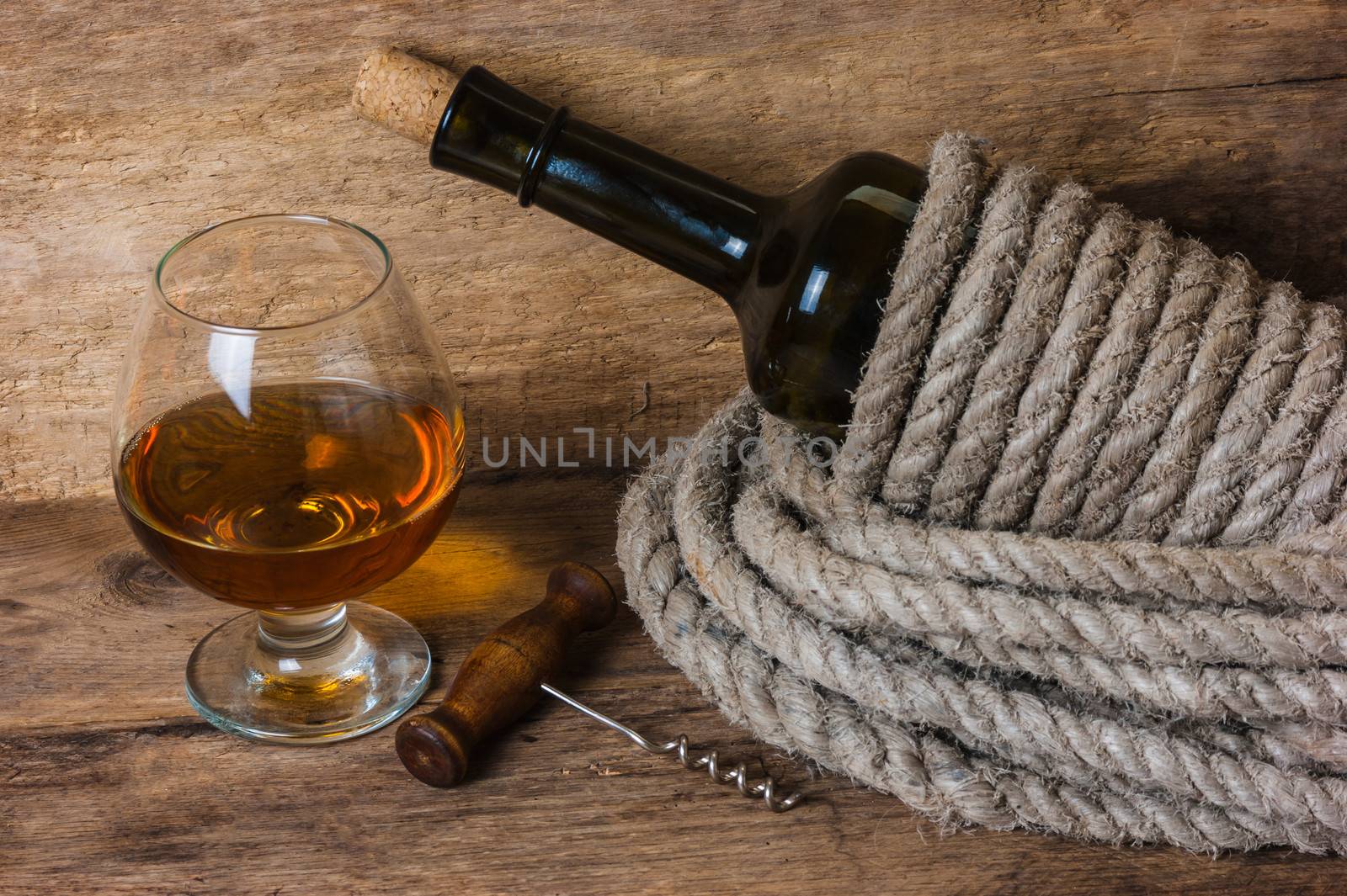 bottle of wine wrapped with rope on the background of the old wooden planks