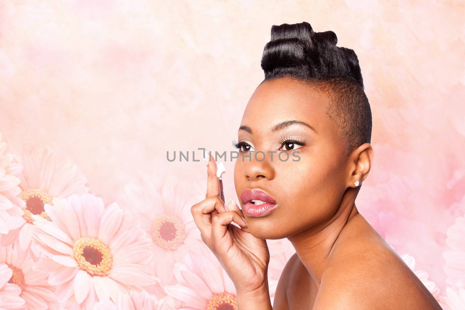 Face of beautiful woman applying facial moisturizer exfoliating anti wrinkle aging cream under eyes, skincare concept, on pink flowers.