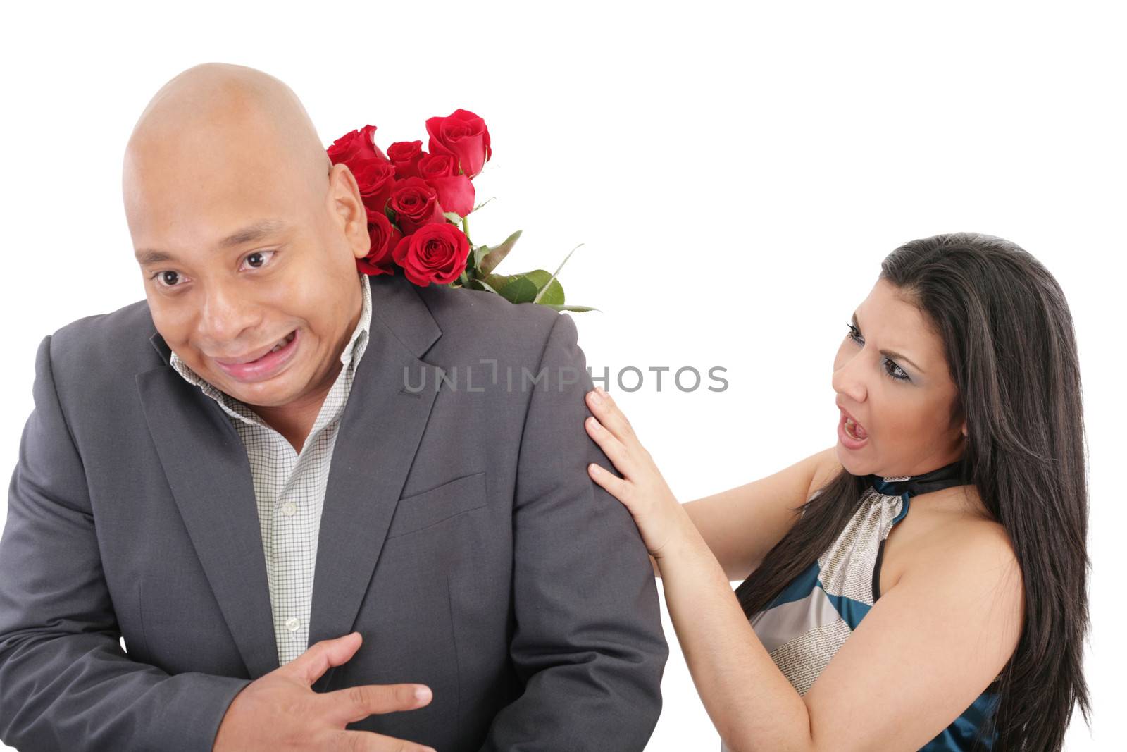 Woman striking his boysfriend with a bouquet of red roses. Focus on the woman.