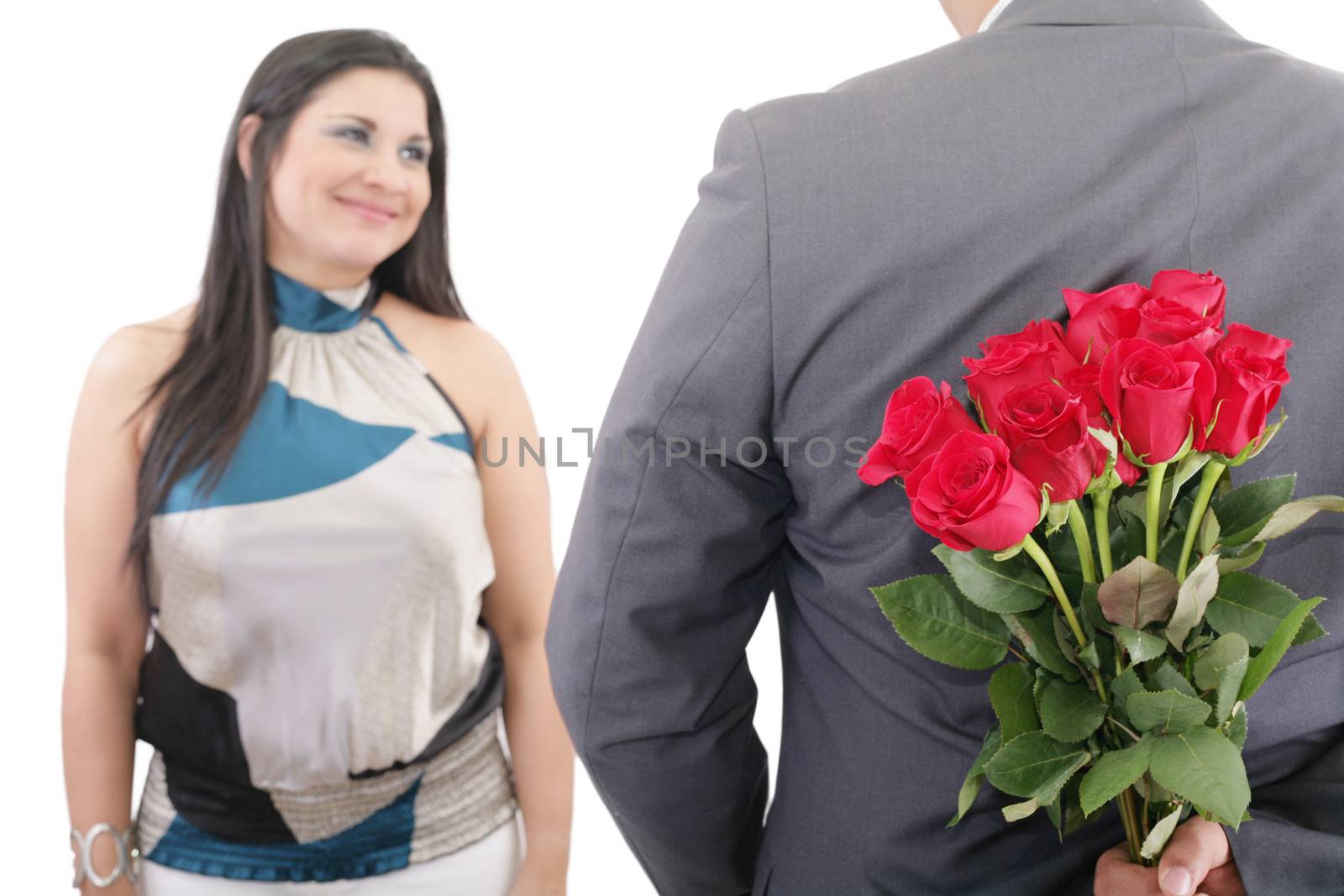 man hiding bunch of red roses behind his back to surprise his girlfriend